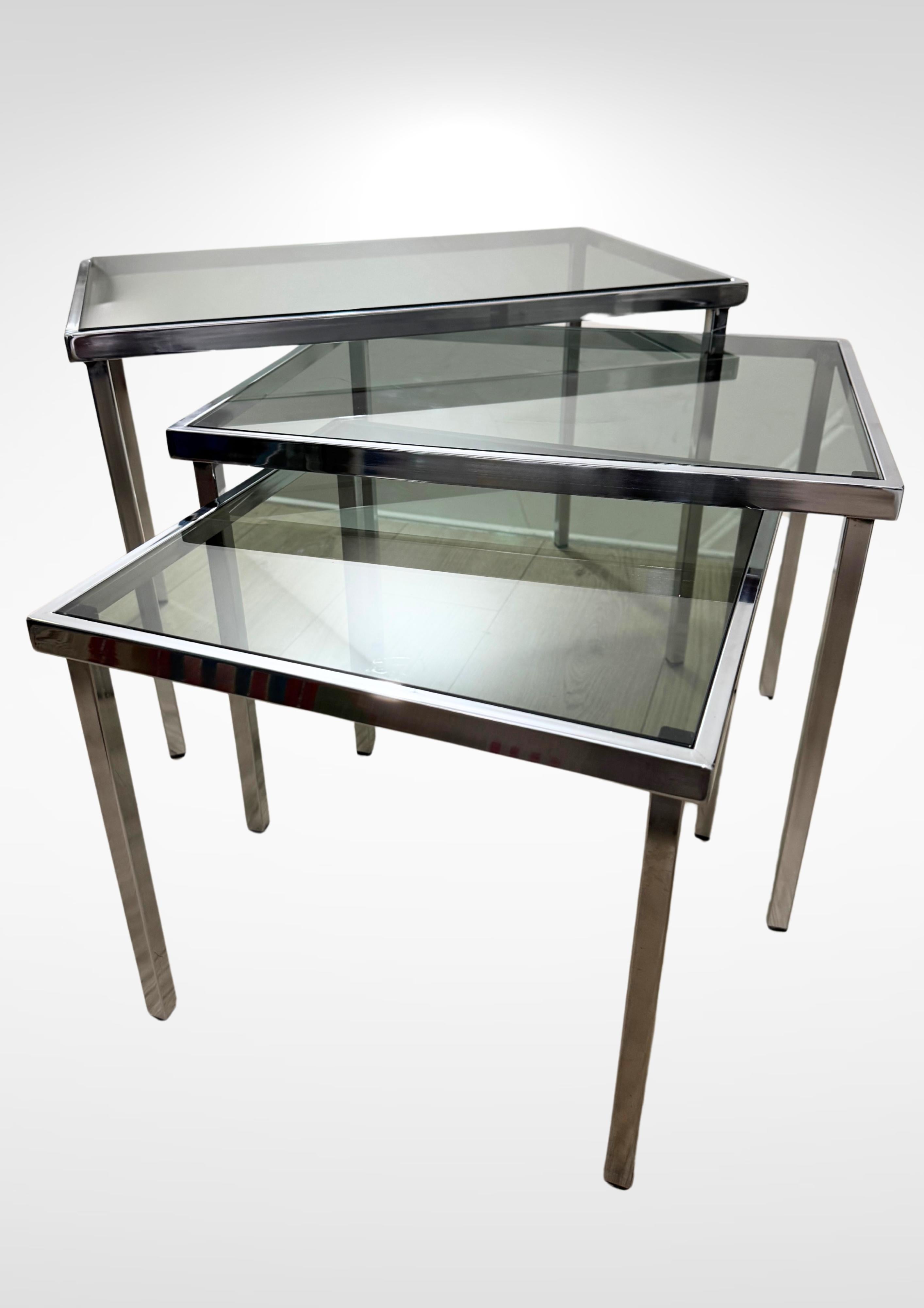 Set di 3 tavolini a nido della metà del secolo scorso alla maniera di Milo Baughman, circa 1970
Si compone di sottili piedini in acciaio cromato con piani in vetro fumé.
Tavoli molto eleganti.
Si abbina alla maggior parte degli interni moderni.