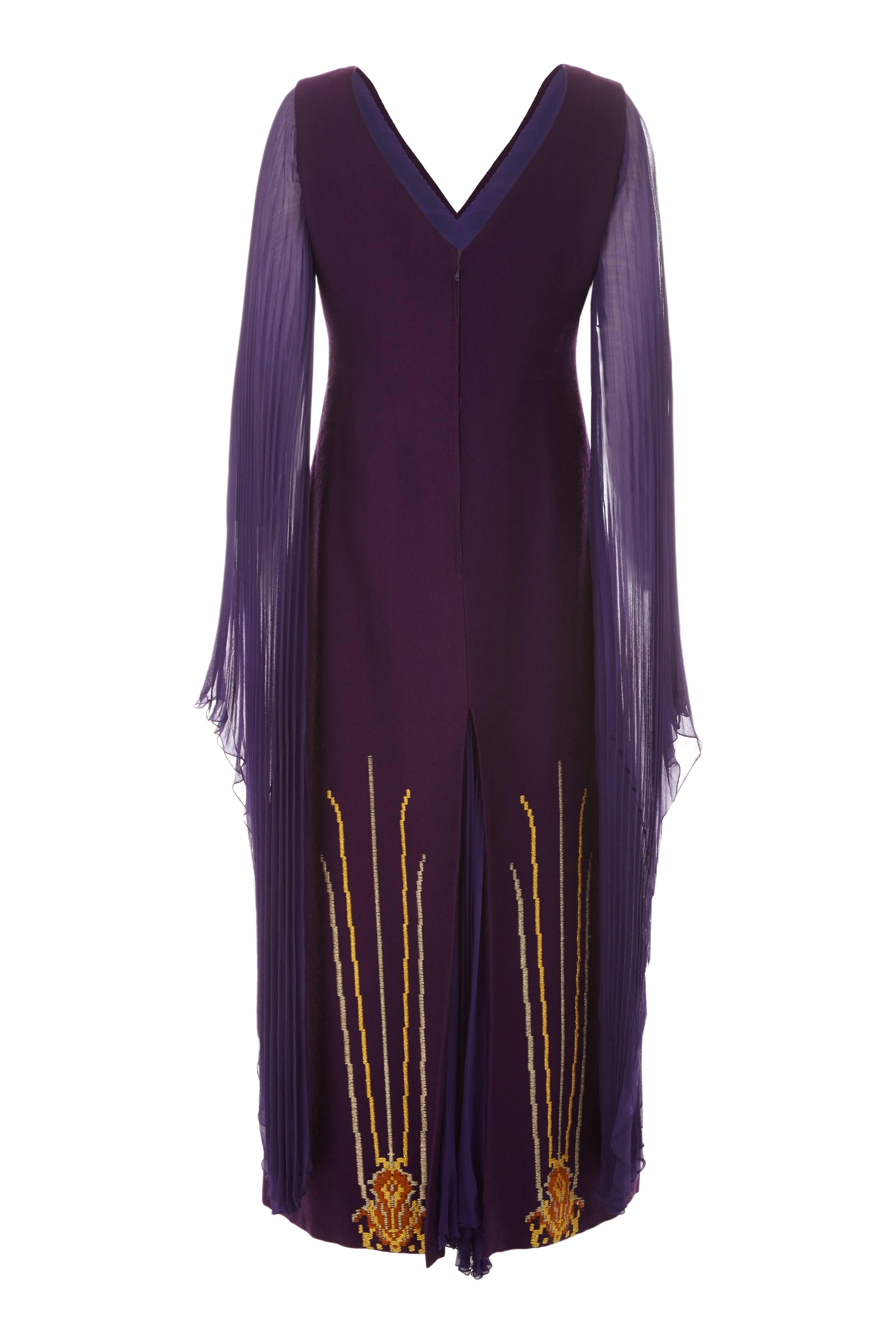 This extraordinary 1970s full length purple wool couture dress is by Greek couture dress is by celebrated Greek designer Nikos-Takis and is of excellent quality. This unusual piece features stylised gold embroidery on the hem and sensational sheer