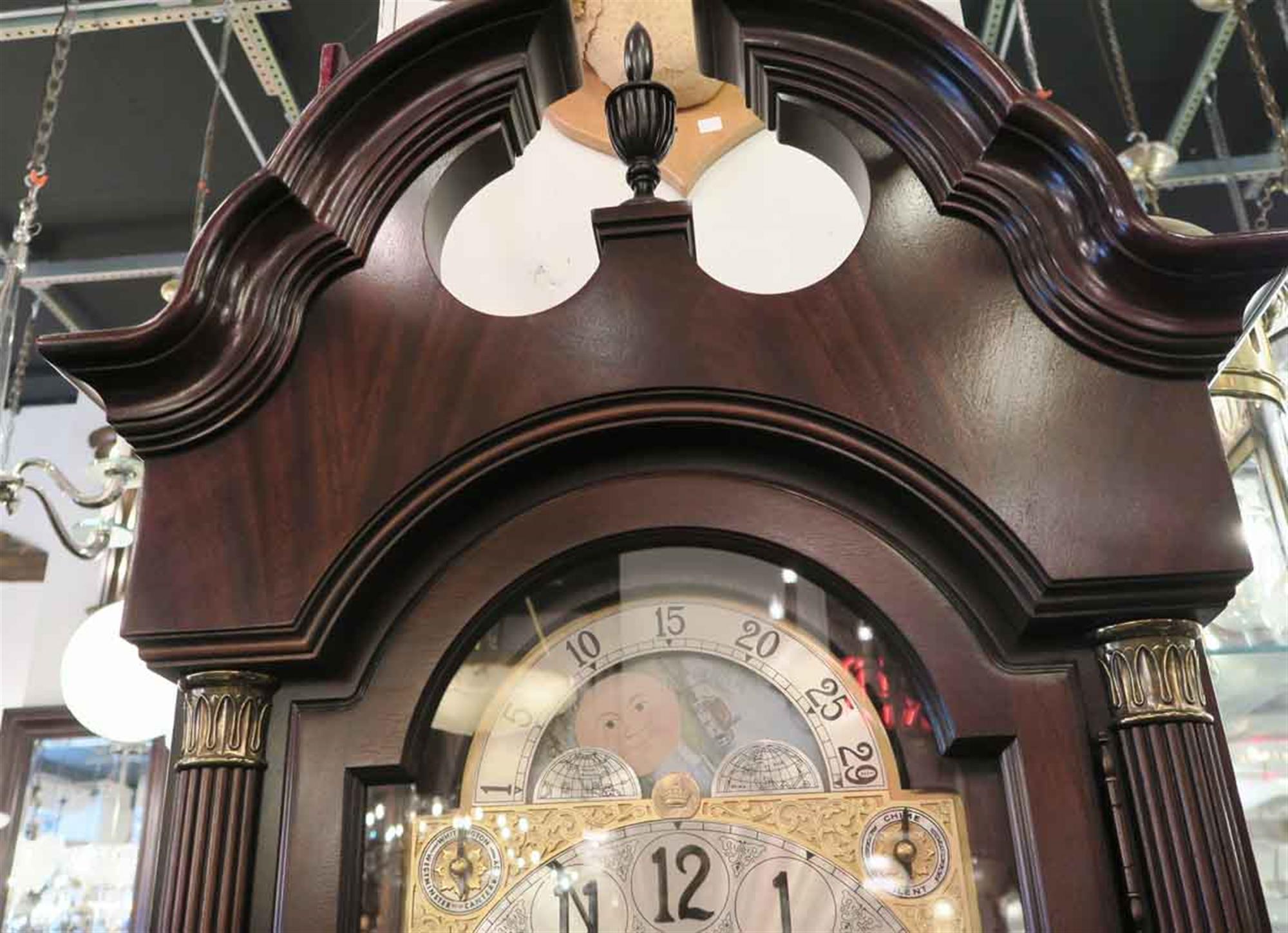 This is a nine tube Herschede grandfather clock, with Westminster, Canterbury, and Whittington chimes. The brass works with moon phase are housed in the mahogany Howard Miller Clock case with reeded columns with brass capitals and bases. The front