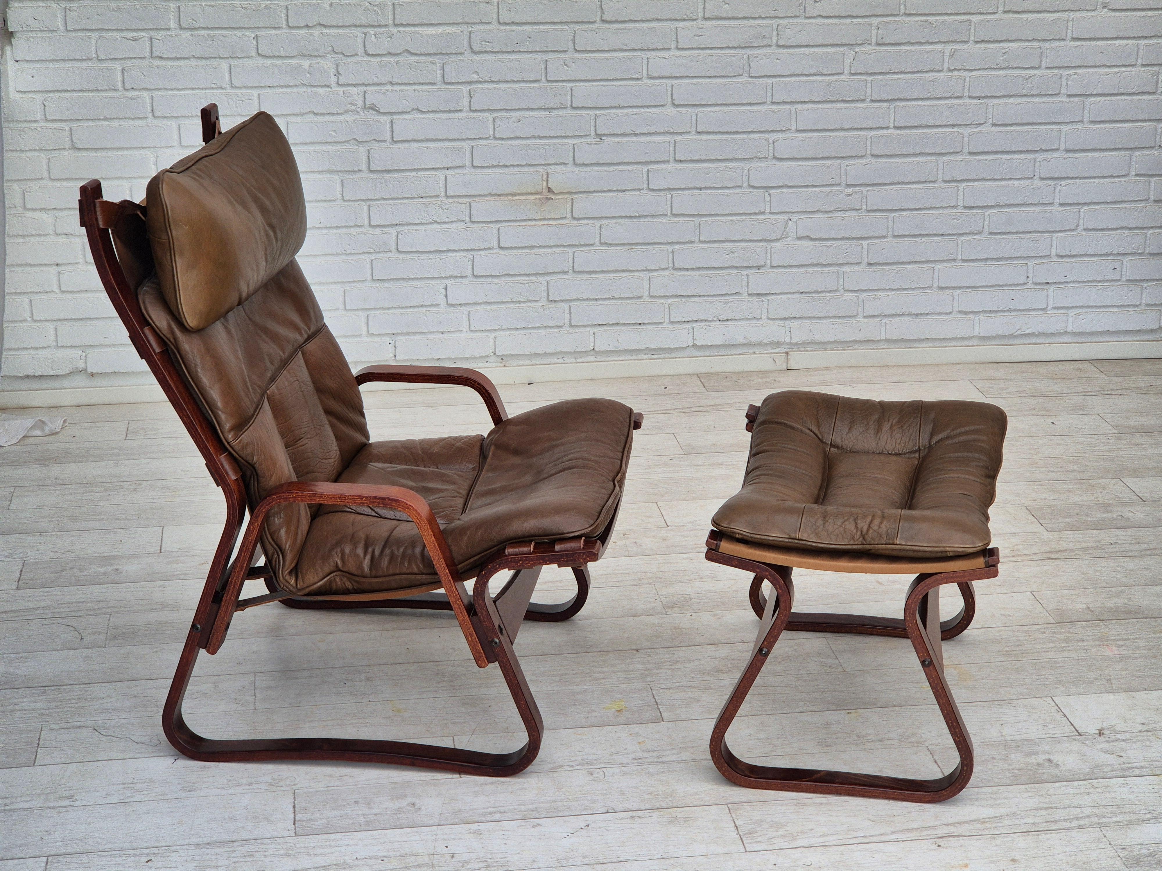 1970s, Norwegian design. Lounge chair with footstool. Original very good condition: no smells, no stains, stable construction. Brown leather, canvas, bent wood. Manufactured by Norwegian furniture maker in about 1970s. The chair was checked by