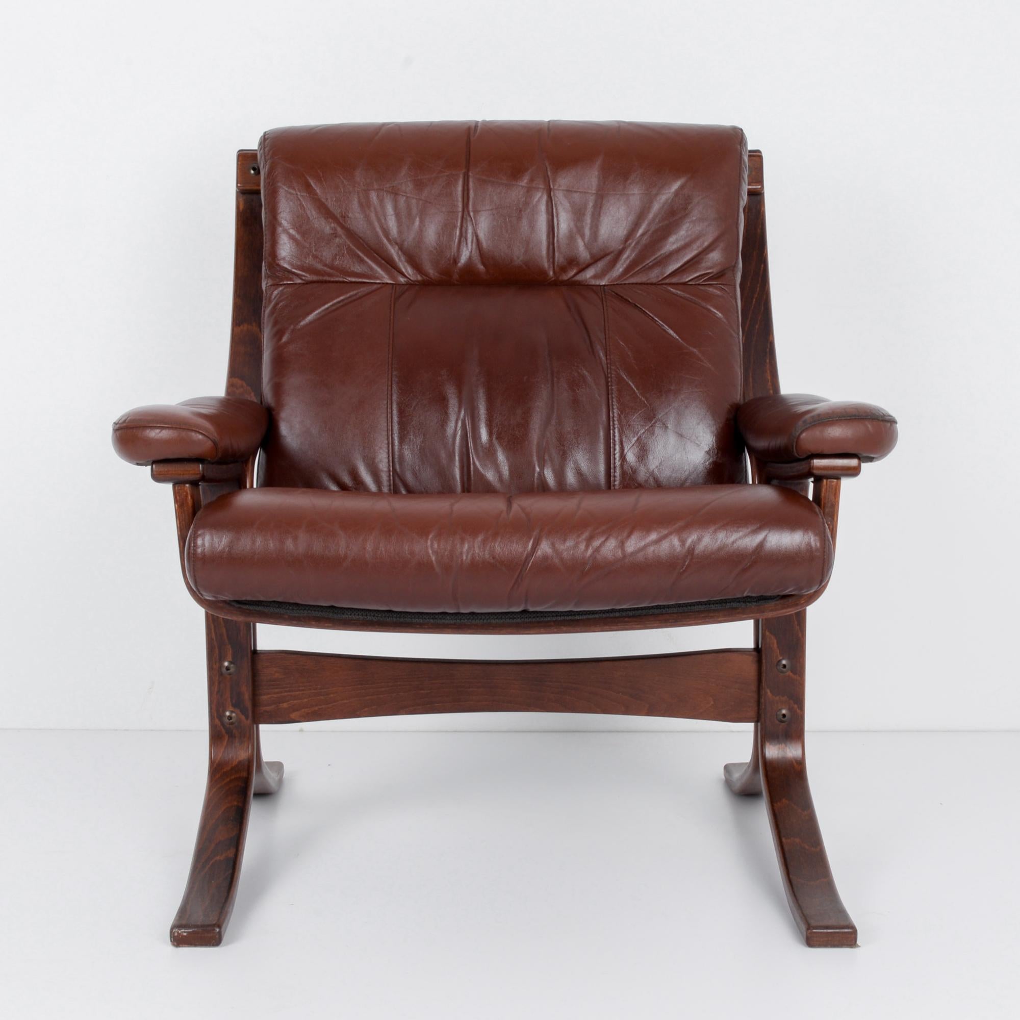 A wooden armchair from Norway with leather seat and back, circa 1970. Luxe comfort, remains sleek while being plush. Easy chair for an approachable intellectual, your new favorite lounge, the centerpiece for a space. Tension of the bent wood