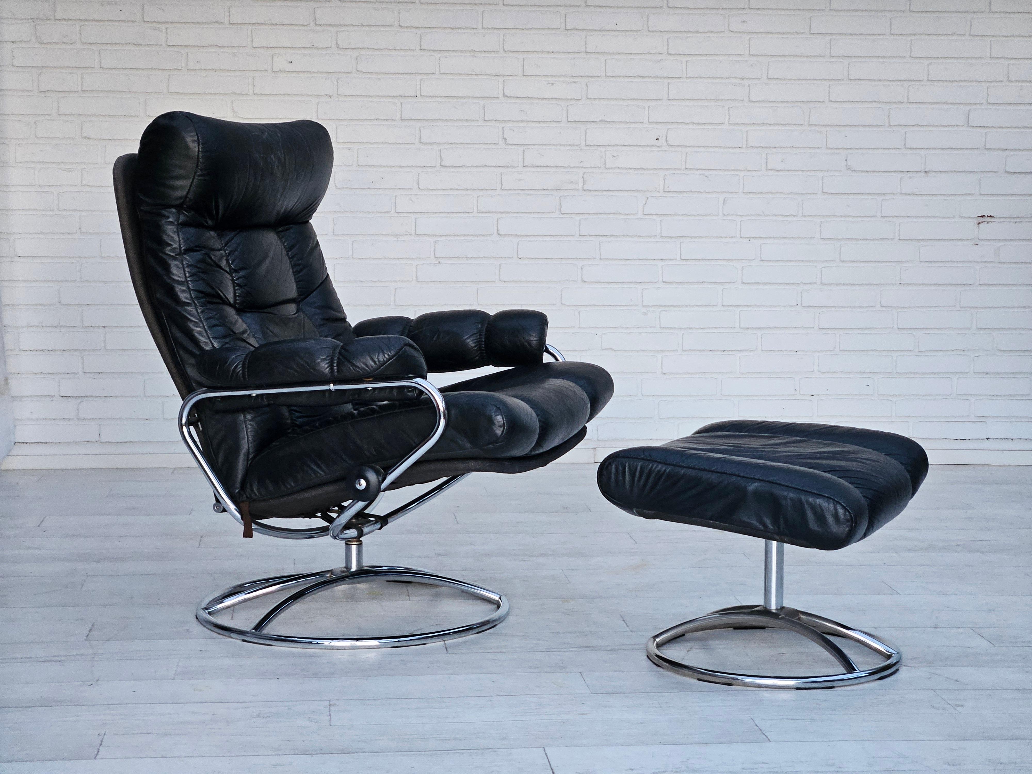 1970s, Norwegian swivel char by Jens Ekornes with footstool in original very good condition: no smells and no stains. Chrome steel base, black leather, canvas. Adjustable seat with backrest. Manufactured by Norwegian furniture manufacturer