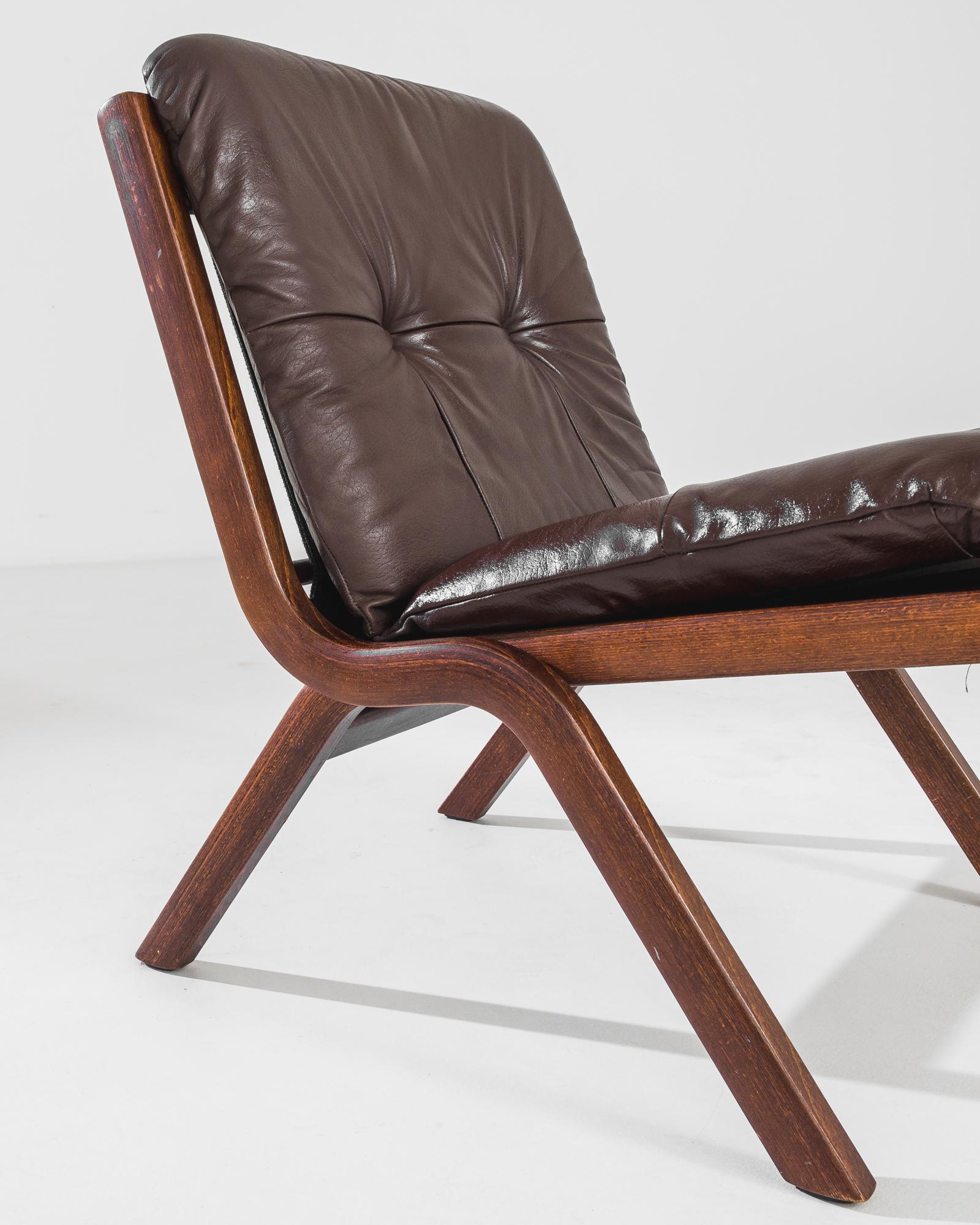 This vintage leather chair was produced in Norway, circa 1970. A wooden chair with upholstered leather back and seat, featuring a bentwood frame with rounded edges and splayed legs. The leather seat and back are in a rich chocolate tone,
