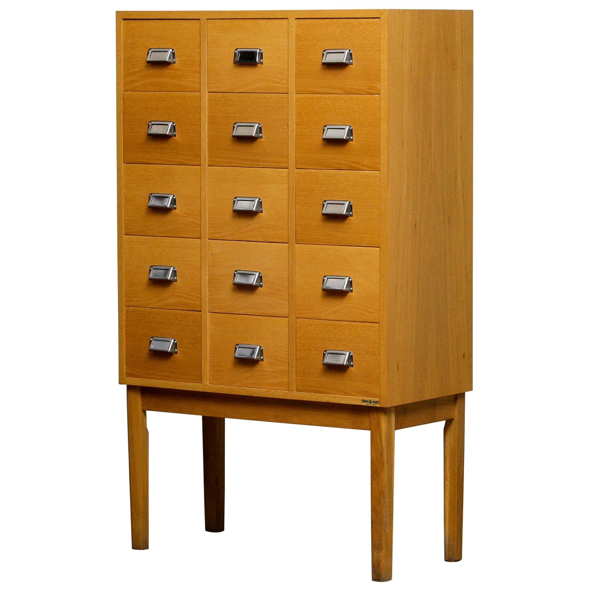 Beautiful and very decorative high legged oak drawer / filing cabinet by Lövgrens Sweden from the 1970s.
Fifteen beech drawers veneered in oak in, overall, good condition.