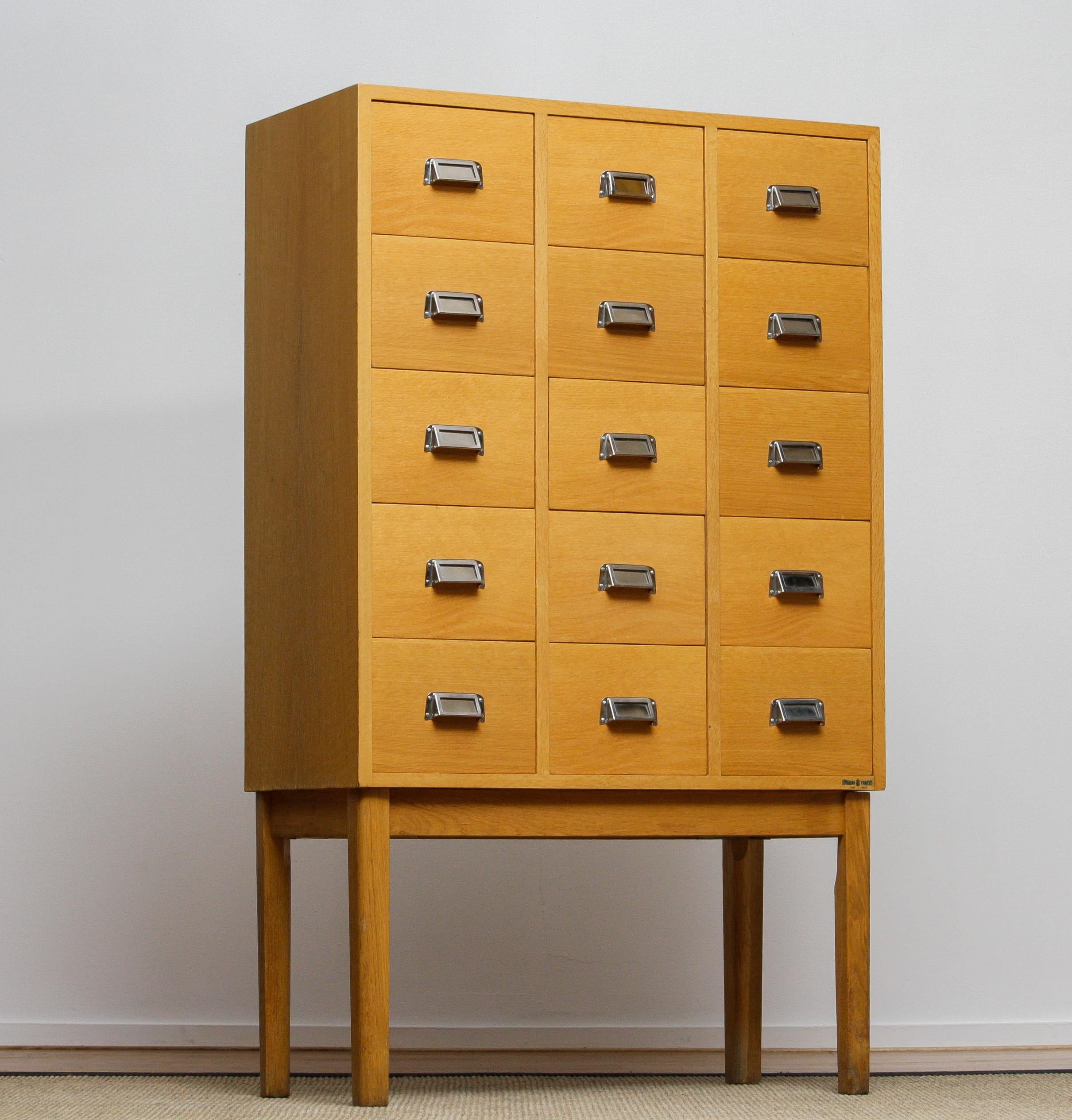 Beautiful and very decorative high legged oak drawer / filing cabinet by Lövgrens Sweden from the 1970s.
Fifteen beech drawers veneered in oak in, overall, good condition.
