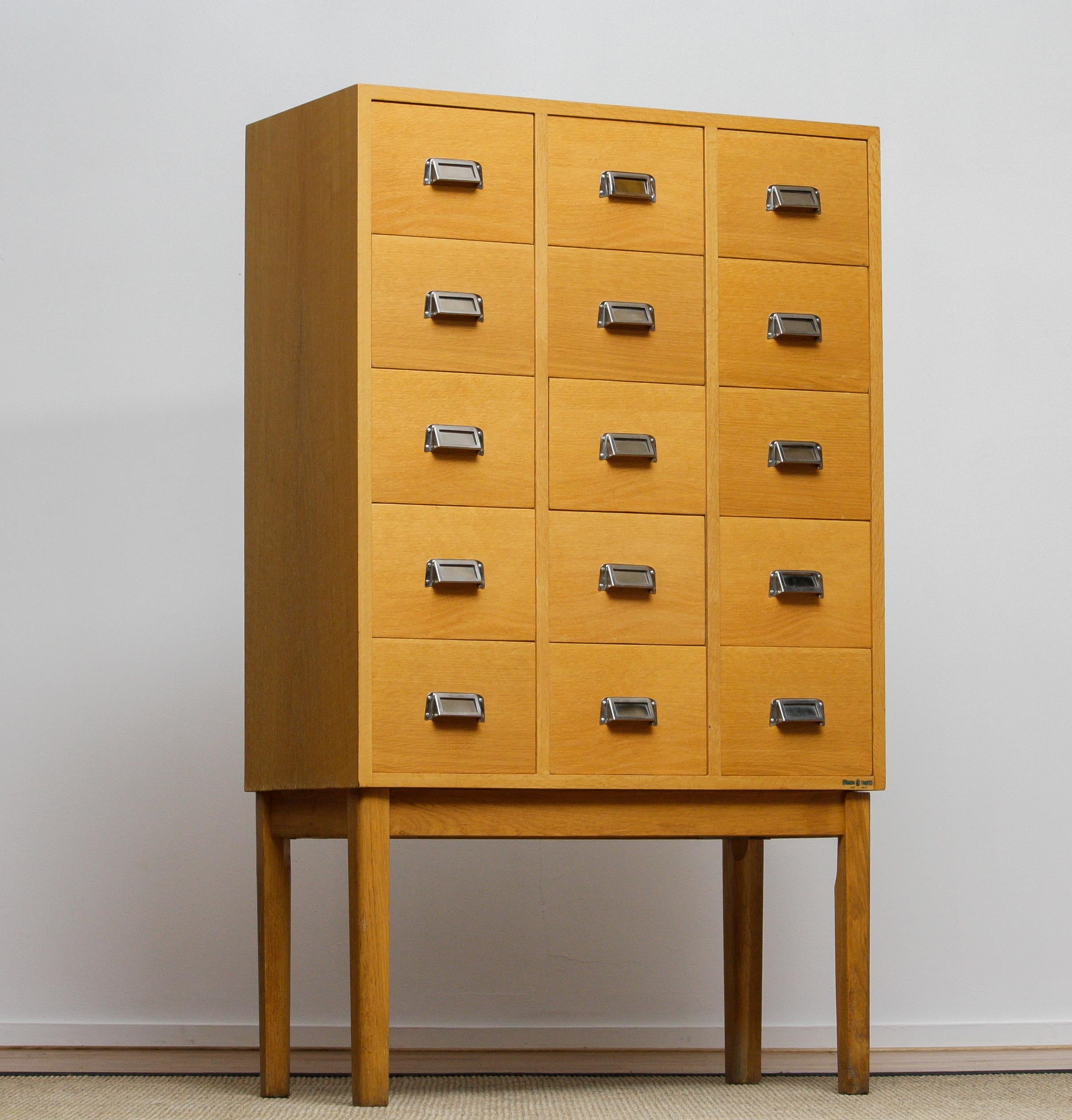 Beautiful and very decorative high legged oak drawer / filing cabinet by Lövgrens Sweden from the 1970s.
Fifteen beech drawers veneered in oak in, overall, good condition.

Please note!
Because Shipping Costs highly fluctuate daily, we kindly ask