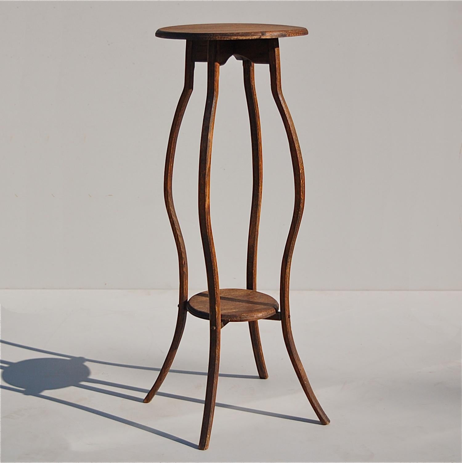 Handmade, slightly rustic, tall, side table, pedestal table, display table or piëdestal with elongated, slim line curved legs. The elegant curvature connects two round platforms suitable for displaying small decorative items or plants. Possibly an