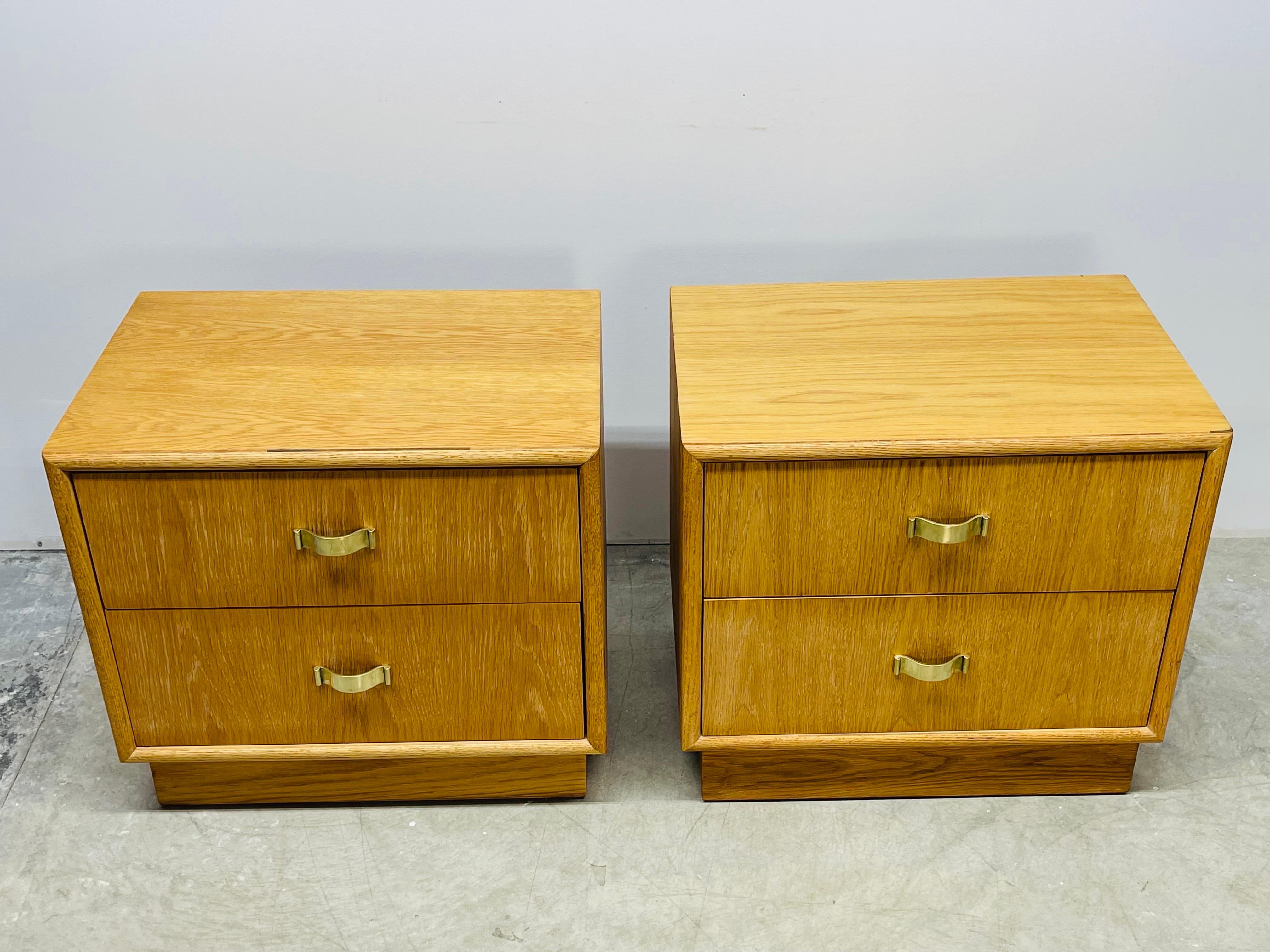 Vintage 1970s pair of oak wood nightstands by Century Furniture Company. The nightstands have two drawers for storage and solid brass pulls. Both nightstands are solid and sturdy. Newly refinished condition. Marked in the drawer.