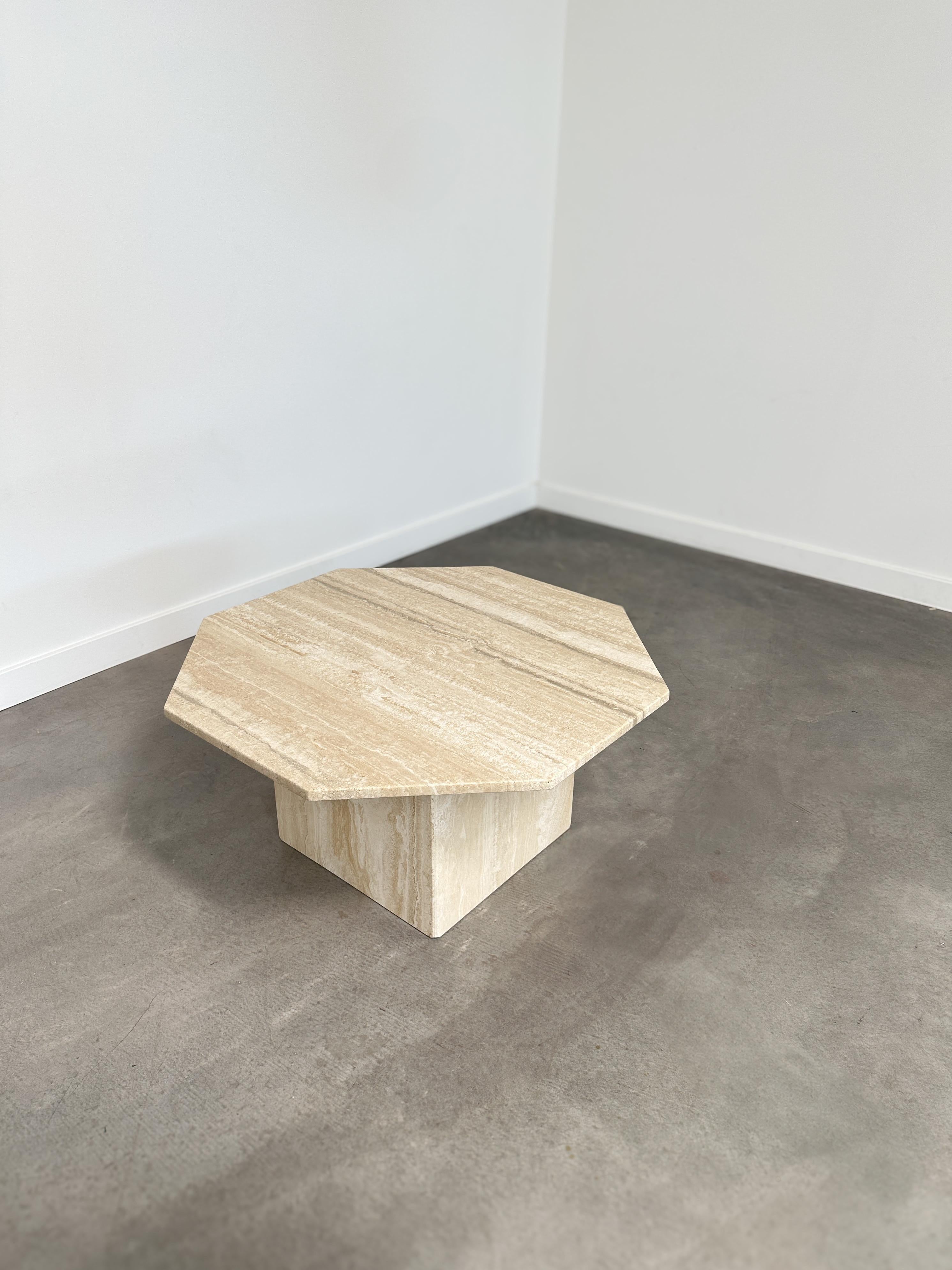 A sculptural standout from the 1970s, this octagonal travertine coffee table pairs clean geometry with organic depth. The square pedestal base supports a crisply honed top, offering a striking interplay of shape and material that feels both grounded
