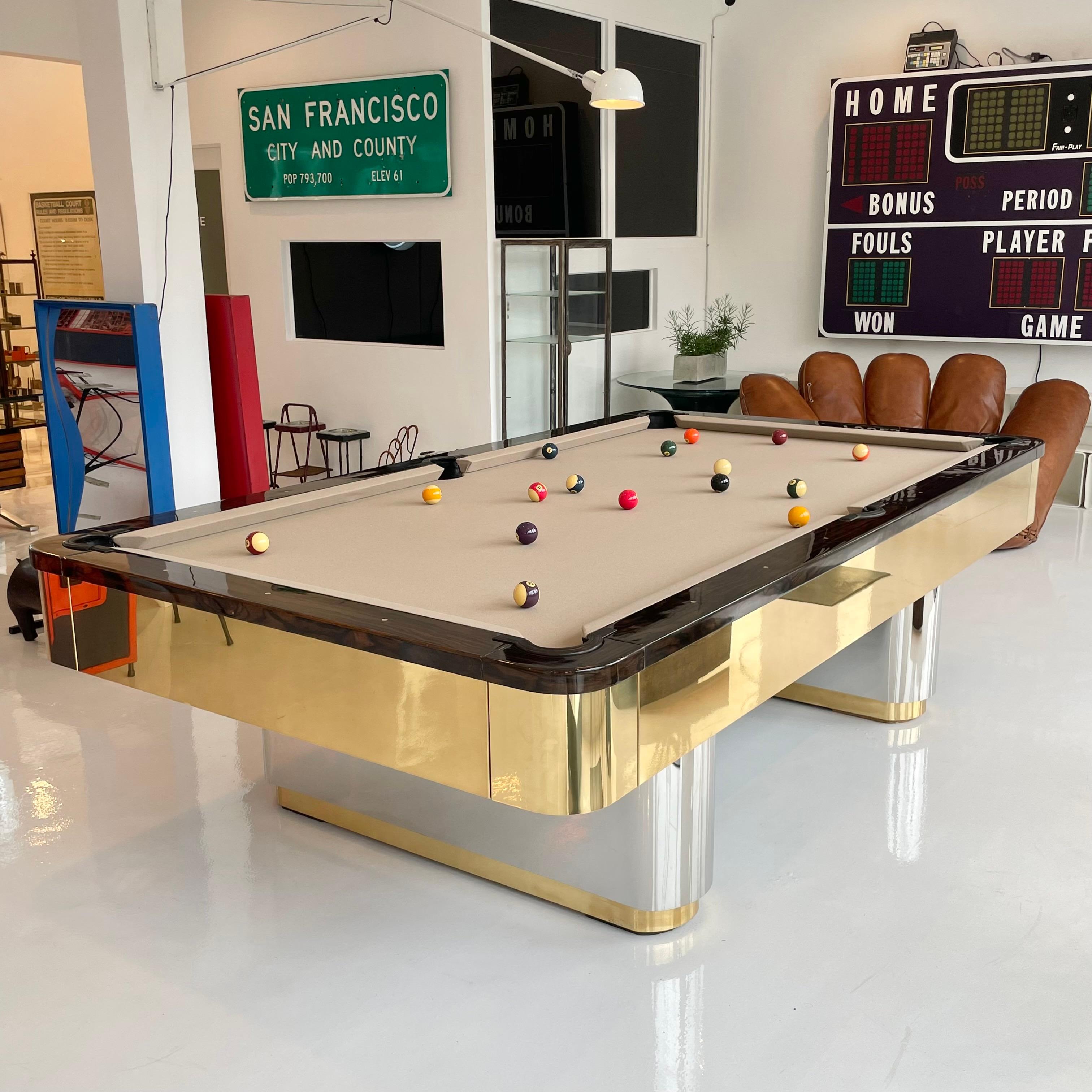 1970s Olhausen pool table. Professional sized 9 foot table. Chrome and brass pedestal bases with brass frame. Desirable 3 piece slate table. Each piece of the pool table has a serial number stamped on it. Comes with matching wall mounted cue holder,