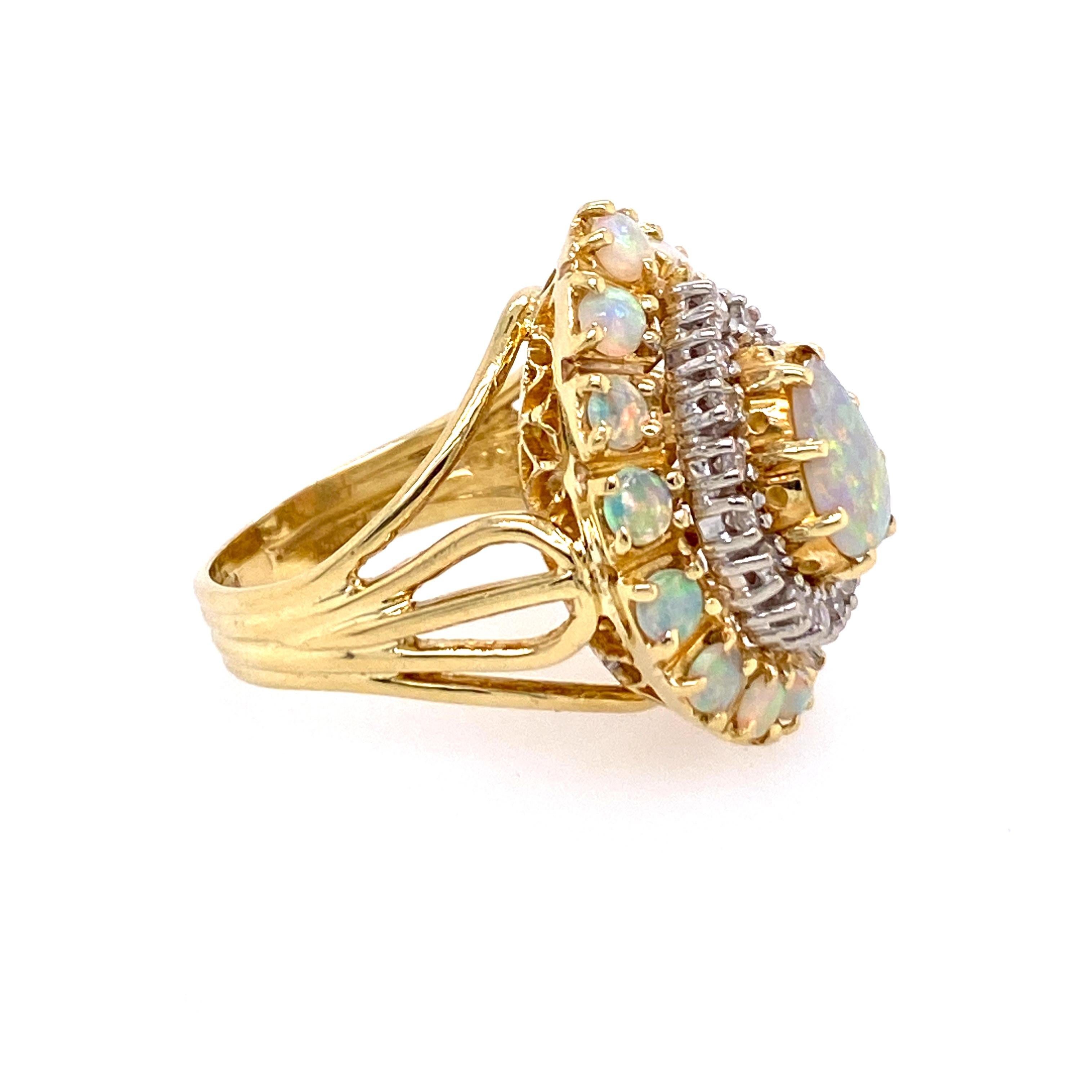 One 18 karat yellow gold (stamped 18KG) ring set with one 8x6mm pear shaped opal surrounded by sixteen single cut diamonds, approximately 0.25 carat total weight with matching I/J color and SI1/SI2 clarity, surrounded by fourteen round 3mm opals. 