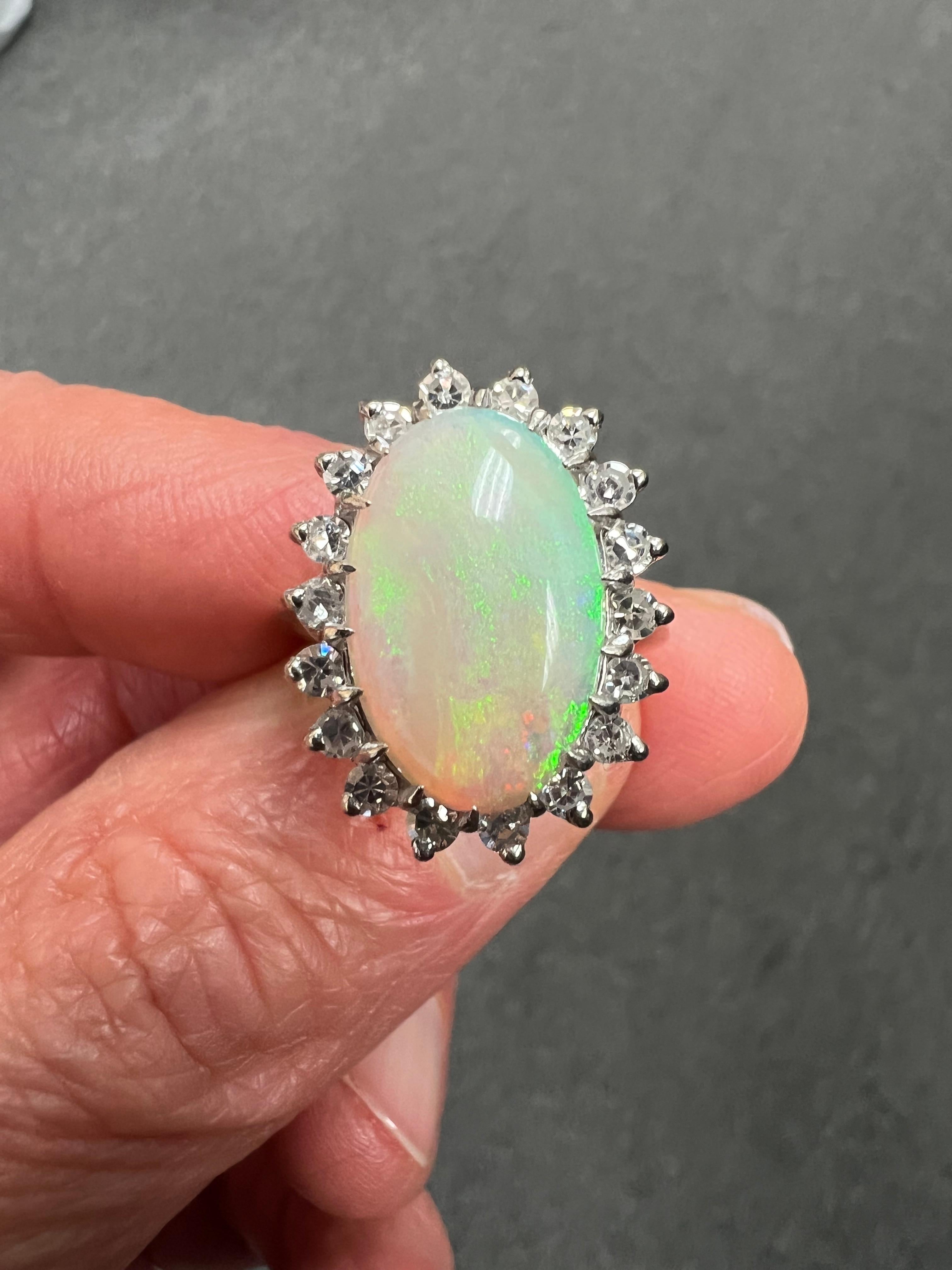 Vintage Opal diamond 14k white gold ring, circa 1970s.

 ABOUT THIS ITEM:  #R-DJ818F   This vintage opal and diamond ring is a basic for anyone's wardrobe. The rich green hues with flashes of blue and red make this opal special.  It is enhanced by a