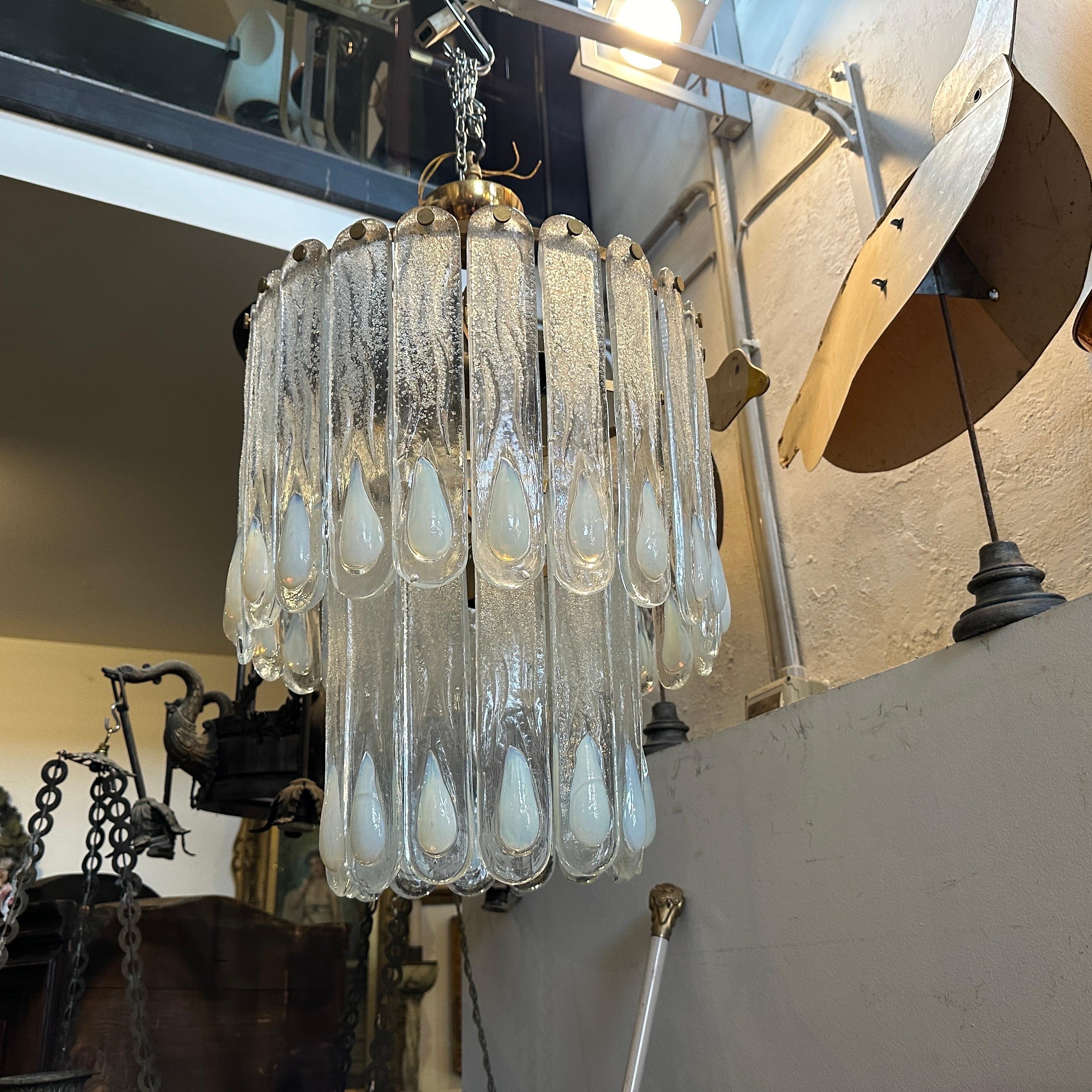 Ein erstaunlicher Kronleuchter aus klarem und opalisierendem Murano-Glas, entworfen und hergestellt in Murano von Mazzega in den siebziger Jahren. Die Gläser sind in einwandfreiem Zustand, und auch die vergoldeten Metallteile sind insgesamt in sehr