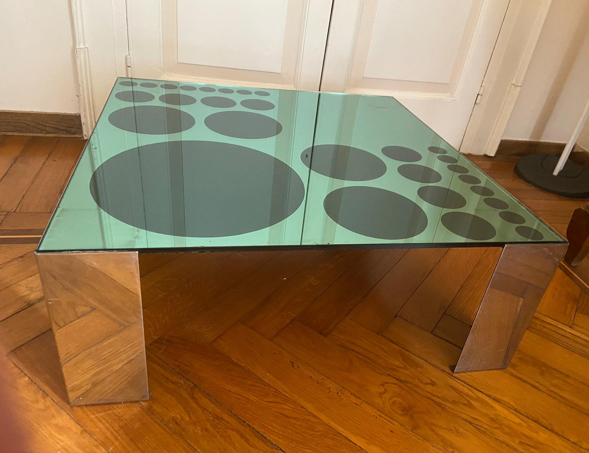 Particular and elegant coffee table made in the 70s with chromed structure and green mirrored glass top with optical designs.