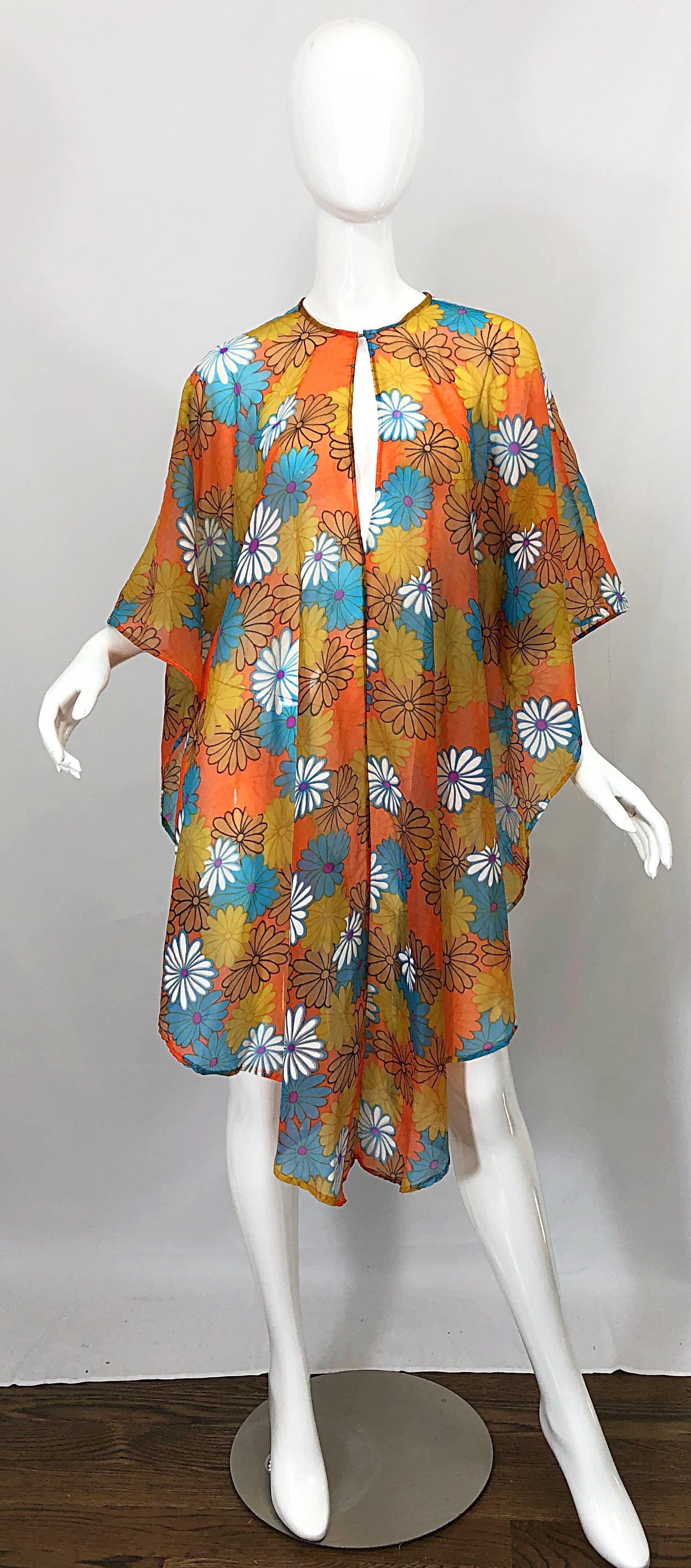 Incredible vintage 70s semi sheer chiffon flower print poncho top! Features vibrant colors in various shades of orange, blue, purple and white. Soft nylon chiffon is both soft and durable. Keyhole at neck can be worn either forward or on the back.