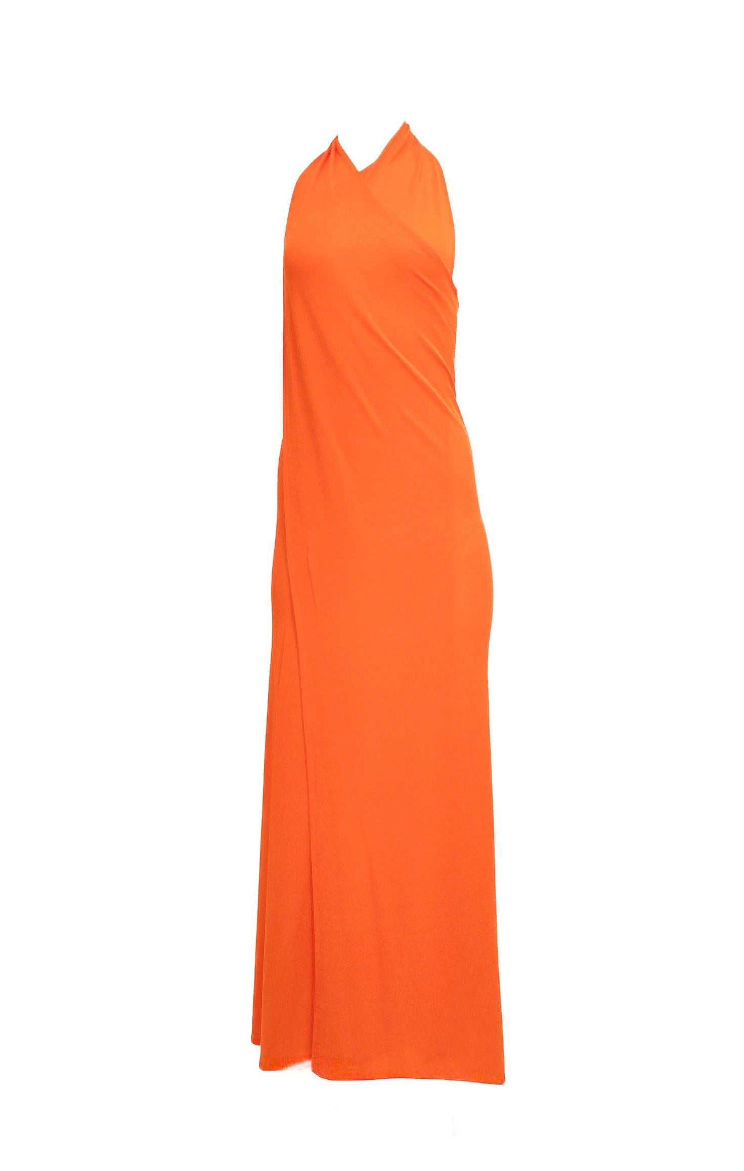 This Vintage 1970s Orange Jersey Wrap Dress features a stretchy fabric that ensures a comfortable, flattering fit. Its bright neon orange hue makes a bold statement, perfect for those who want to stand out from the crowd. The adjustable wrap design