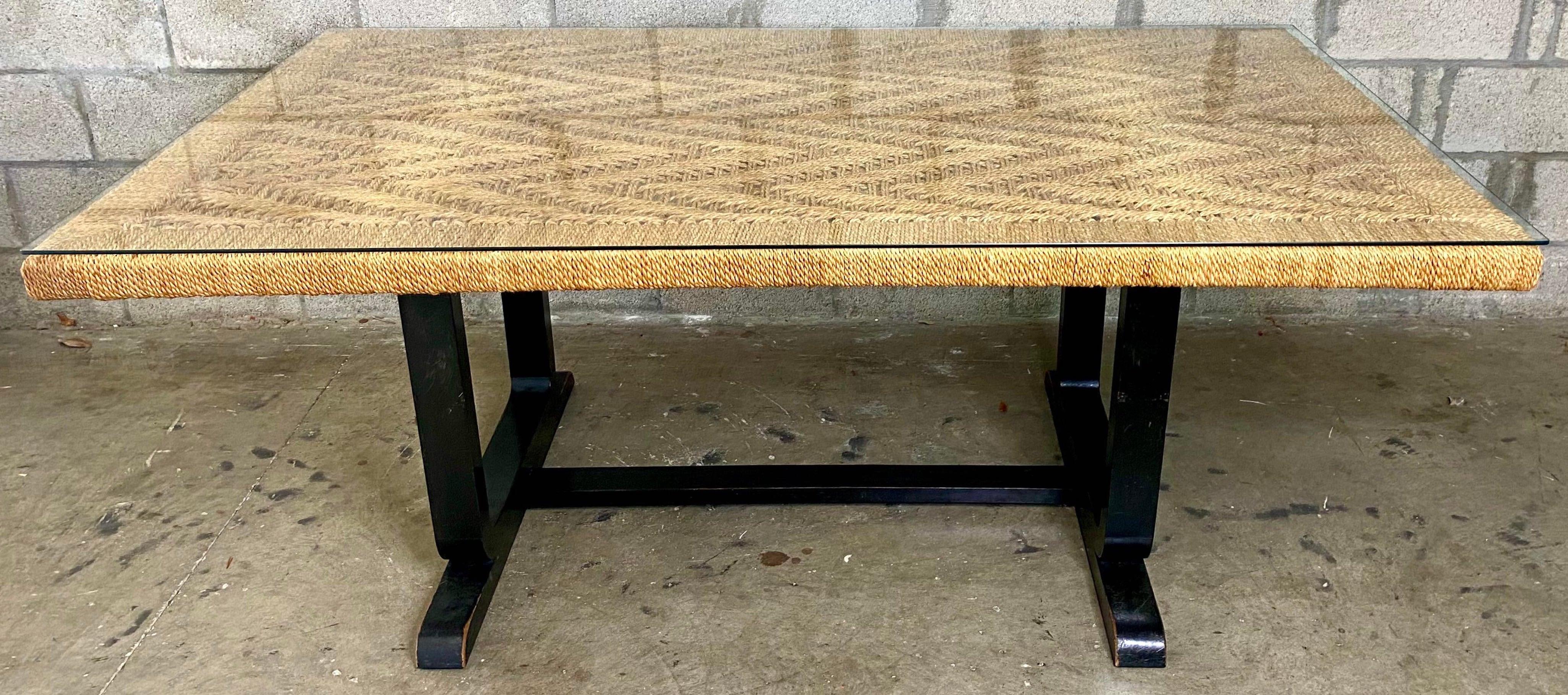 1970s Organic modern woven jute desk or dining room table
of rectangular form with flame-stitch woven jute top, resting on a ebonized wood trestle table base.