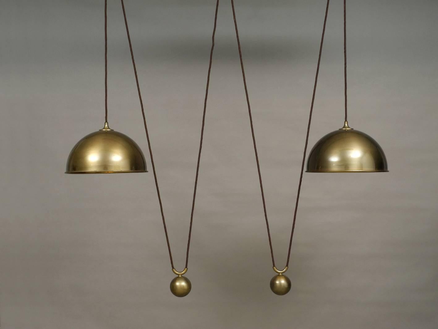 Imposing 1970s original Florian Schulz double drawbar ceiling lamp made of heavy dark brass. Individually adjustable to every height. Heavy pendulum weights.
Very elegant minimalistic design. A classic among the lamps by Florian Schulz and very