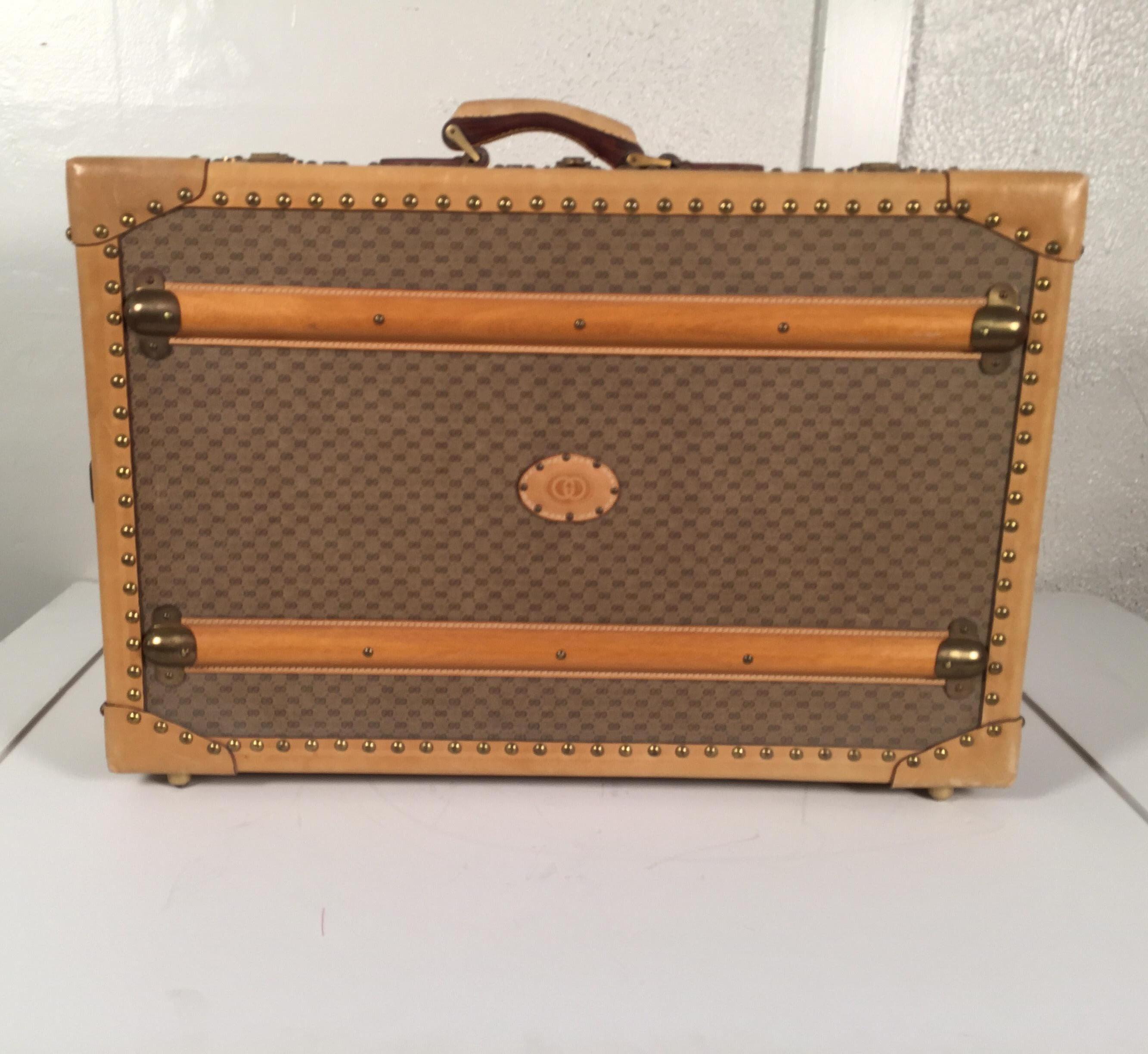 1970s original Gucci logo hard sided suitcase or travel trunk, excellent unused condition.
Scarce hand sided Gucci suitcase with brass hardware and leather and brass nailhead trim. Wooden slats on the side bound by brass to protect the