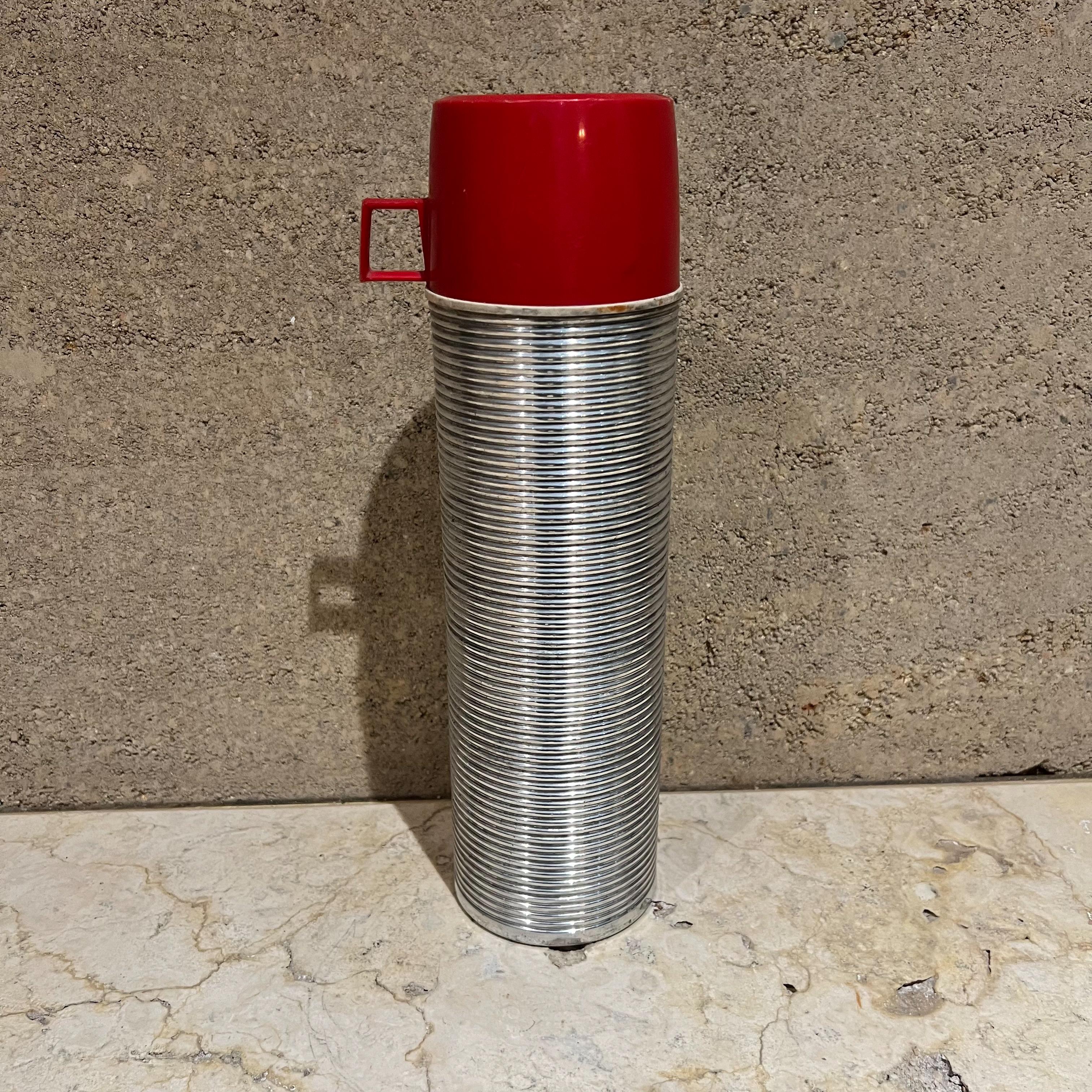 Vintage gerippte Thermos Retro Camp Gear USA, 1970er Jahre
Thermoskanne im Quartformat mit rotem Becher. 
Isoliert.
13,25 hoch x 3,75 Durchmesser Becher 2,5 hoch x 3,75 Durchmesser x 4,75 d
Originaler Vintage-Zustand. Alle Bilder anzeigen.
