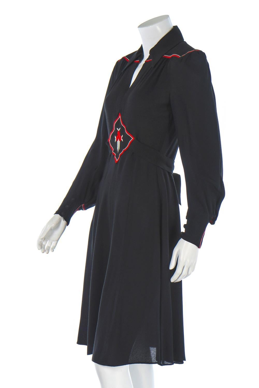 1970’s Ossie Clark black moss crêpe knee-length day dress with waist ties and abstract floral-themed embroidery in red and white at the midriff and cuffs by Celia Birtwell. Made in England, UK size 10. In excellent condition.

Shoulders:
