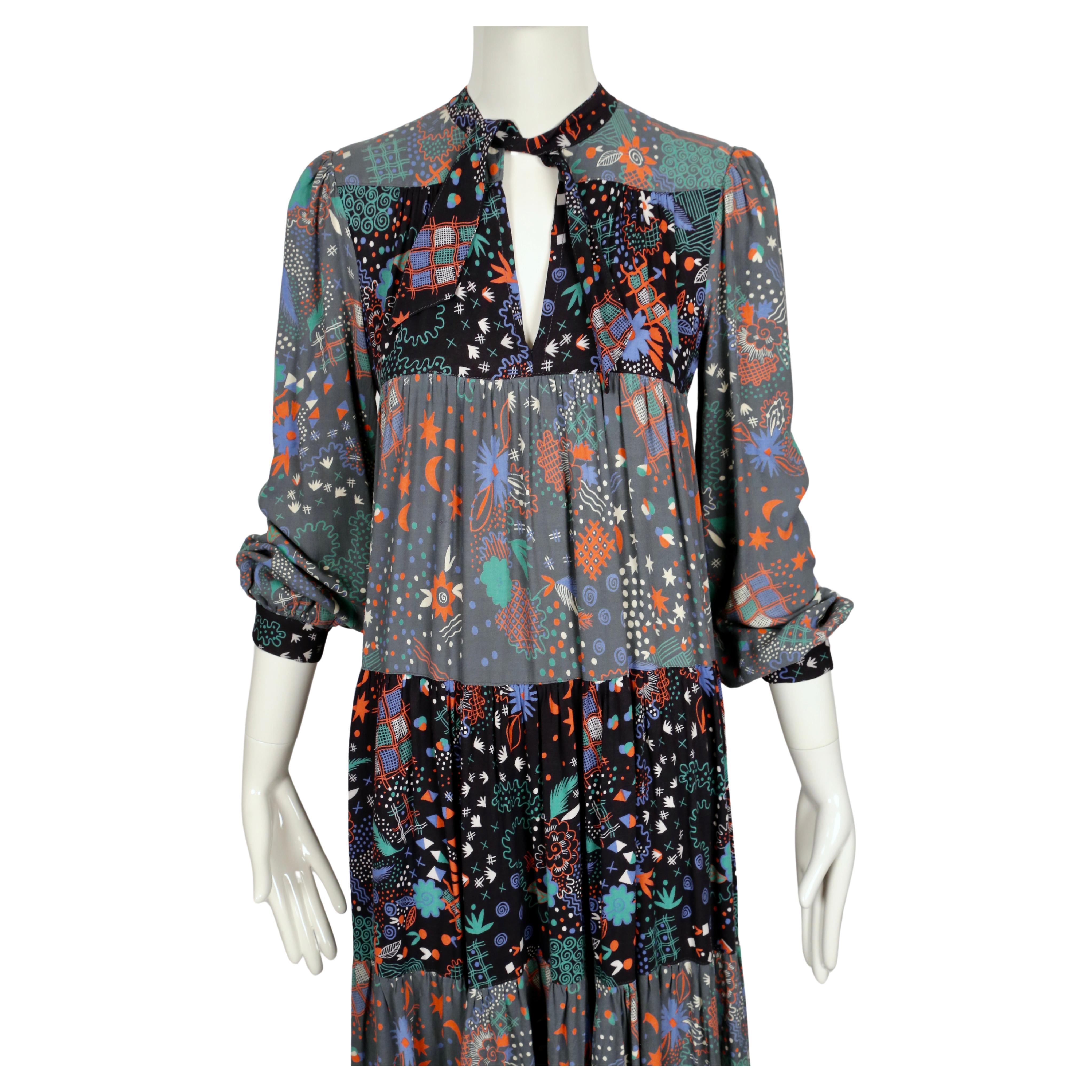 Very rare, tiered dress made of contrasting Celia Birtwell printed fabric designed by Ossie Clark dating to the 1970's. Dress features puff sleeves and a cut out at neckline with a tie. Cuffs at wrists. Dress is labeled a UK size 12 however there is