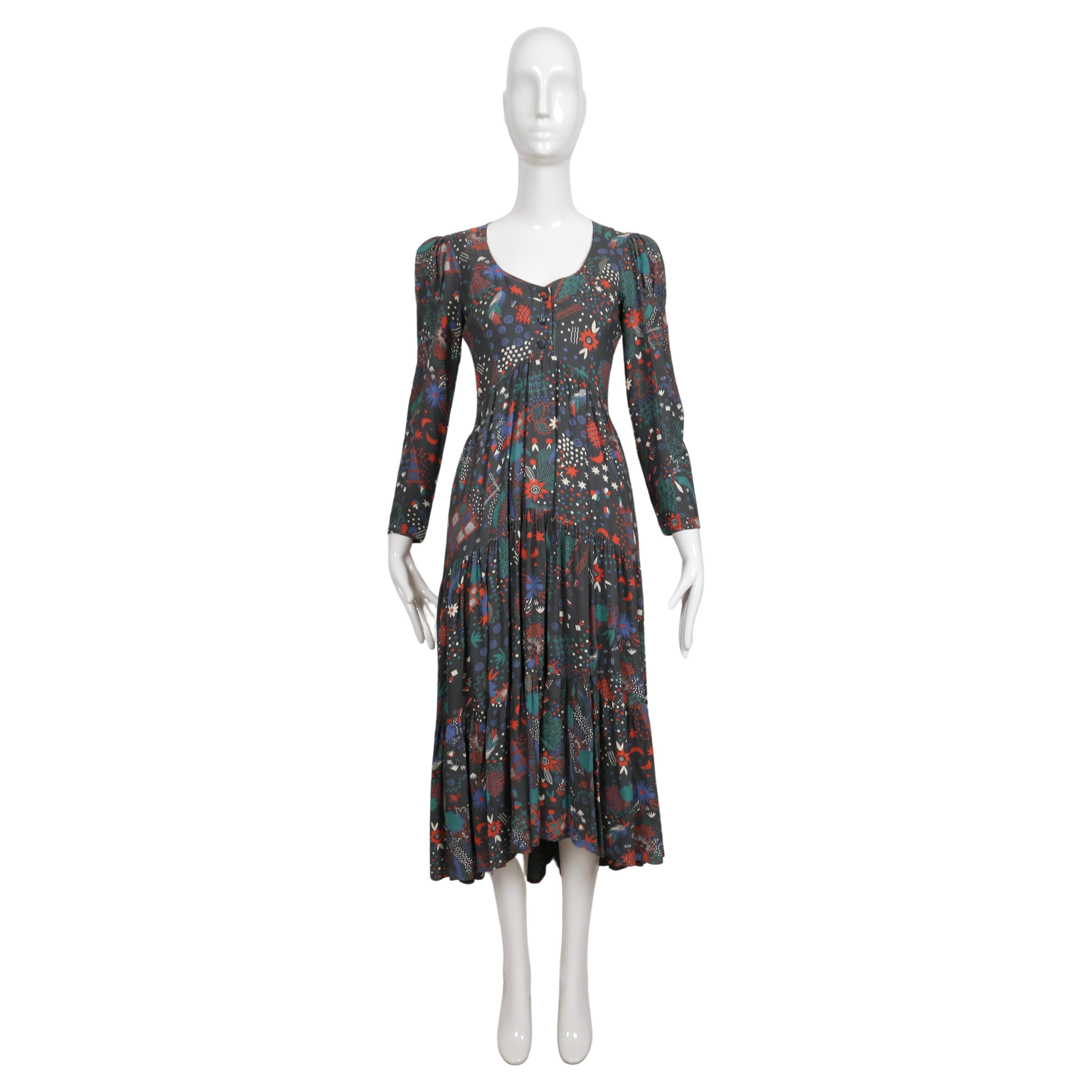 Very rare, tiered dress made of Celia Birtwell printed fabric designed by Ossie Clark dating to the 1970's. Dress features puff sleeves, a low cut neckline with button closure, an empire waist and a high-low hemline. Dress is labeled a UK size 12
