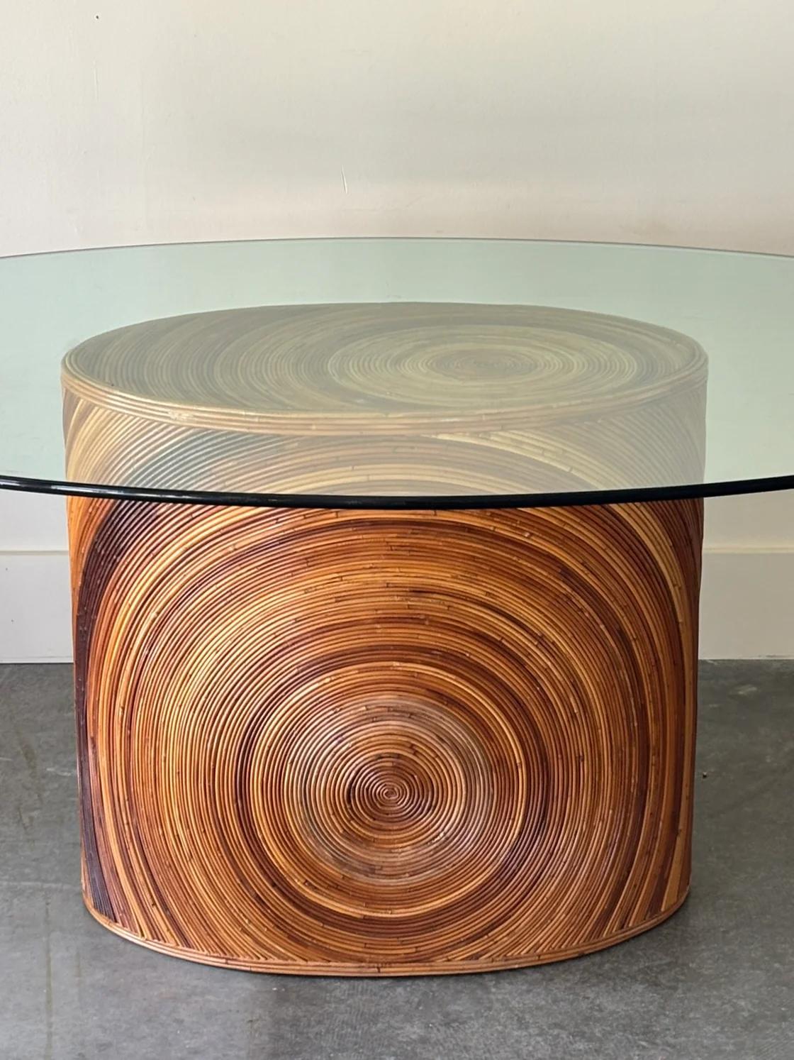 Table ovale en roseau à base de crayon, plateau ovale en verre, avec des tons chauds de brun miel et un magnifique motif de roseau en cercle. Le Condit est en excellent état et ne présente aucun signe d'usure. Le verre présente de très légères