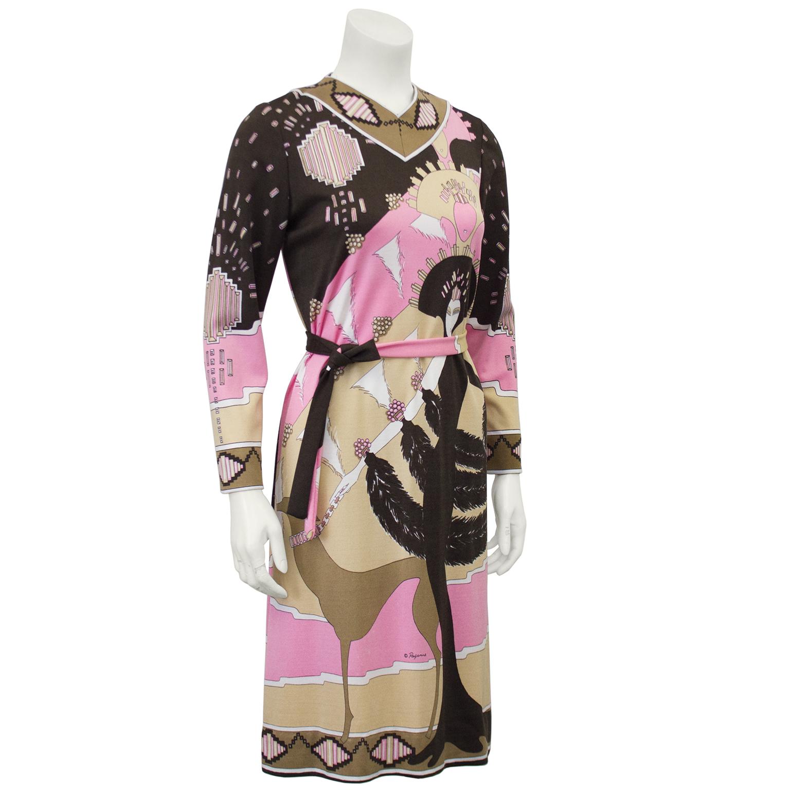 Pink and brown printed rayon Paganne dress from the 1970s. The long sleeve dress has a V neckline and comes with a simple detached rope belt made from matching fabric. The show stopping Art Deco inspired printed fabric features a regal woman with an