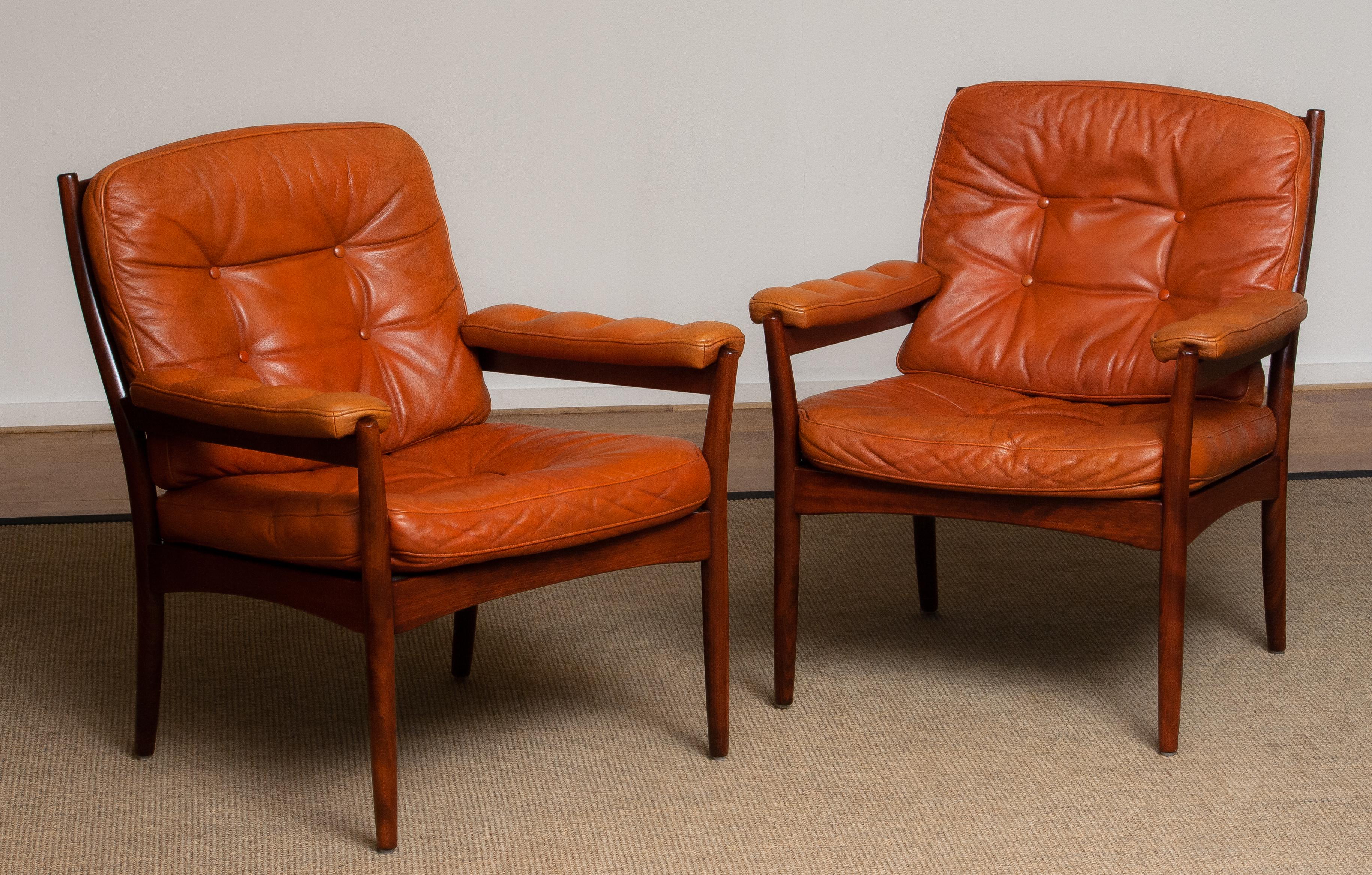 This set of two armchairs are made in the 1970s by Göte Möbels Nässjö in Sweden. The frames are made of beech in mahogany color and they are upholstered with sturdy cognac leather.
These are chairs are very comfortable and their overall condition