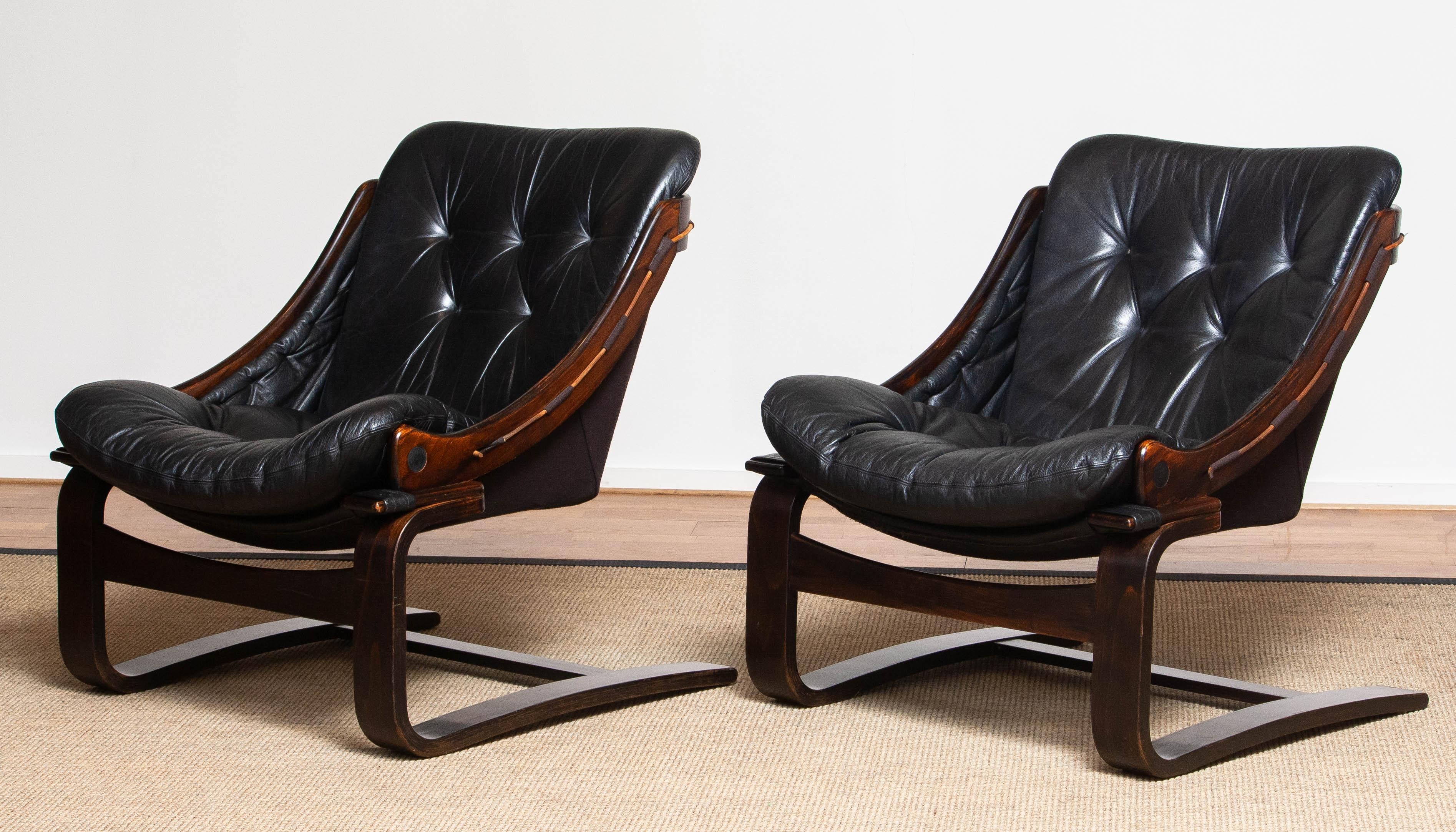 Original set of two Scandinavian lounge chairs designed by Ake Fribytter for Nelo Möbel in Sweden.
Both are upholstered with black leather and dark brown linen.
Overall in good condition.