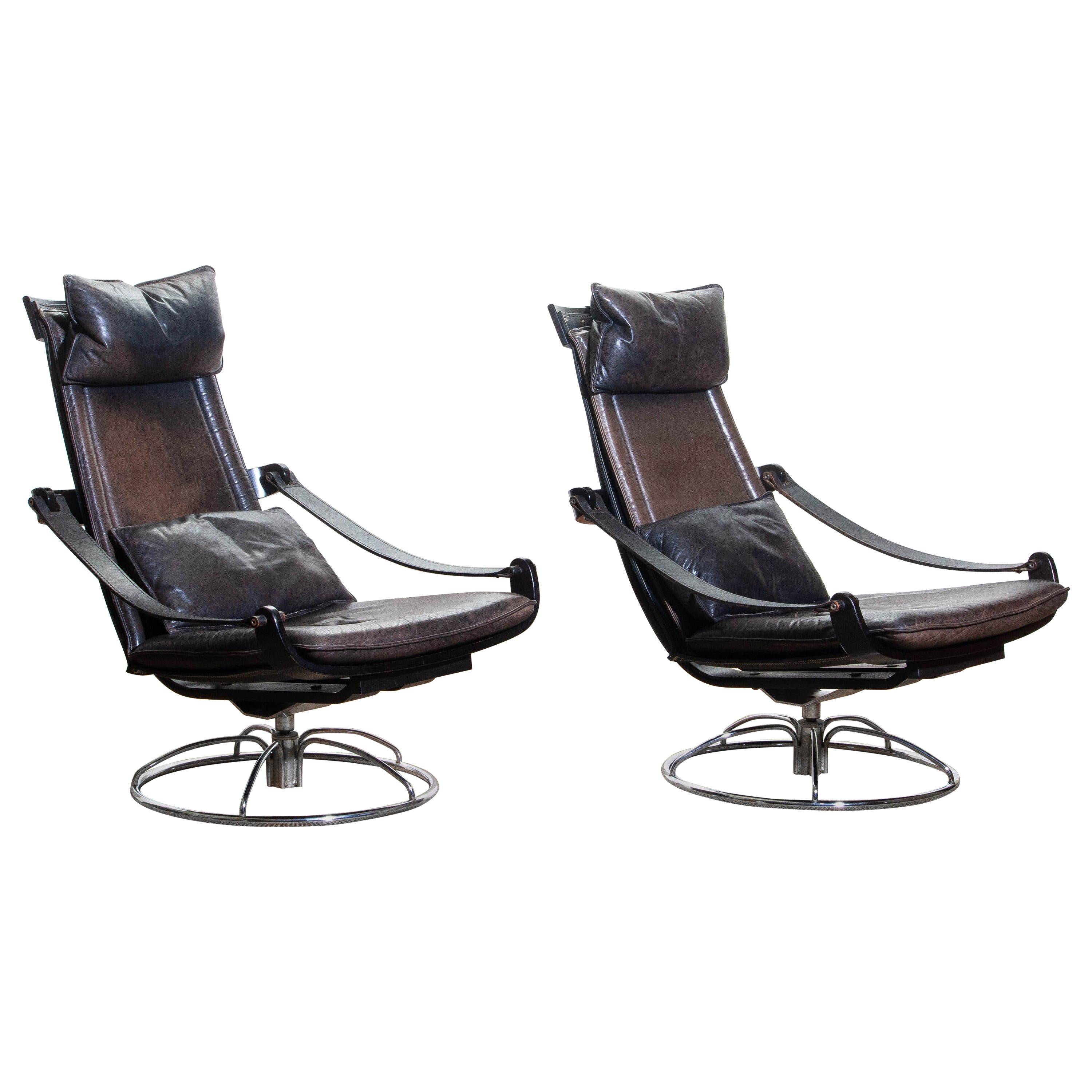 Extremely beautiful and artistic set of two swivel easy / lounge chairs designed by Åke Fribytter for Nelo, Sweden.
These high quality chairs features a plywood frame and brown leather cushions and a chromed metal base.
The armrests are made of