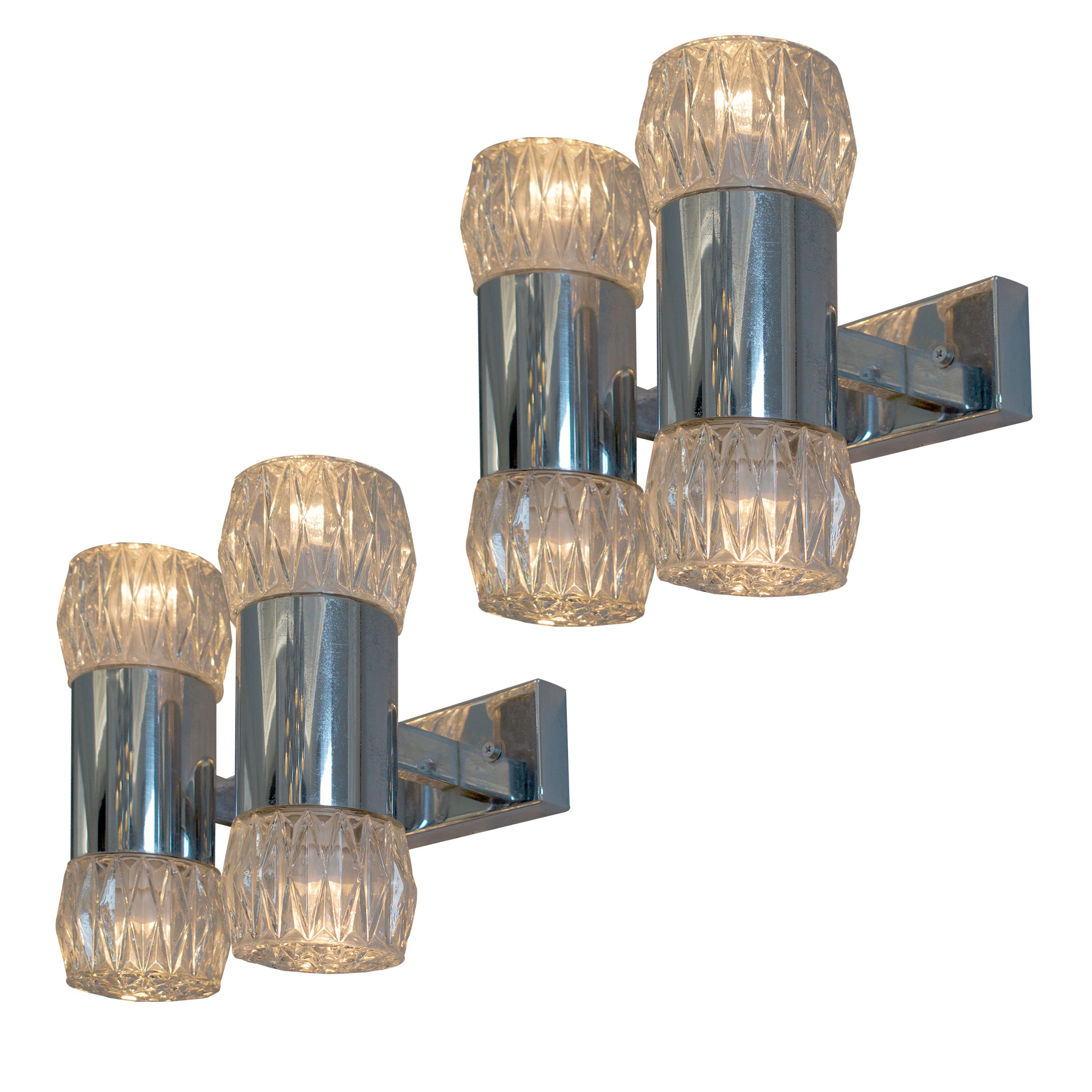 The Pair of Chrome and Glass Wall Lights designed by Gaetano Sciolari, crafted in Italy during the 1970s, is a testament to the enduring charm of Italian design. With their sleek chrome frames and screw-on glass shades, these fixtures offer a blend