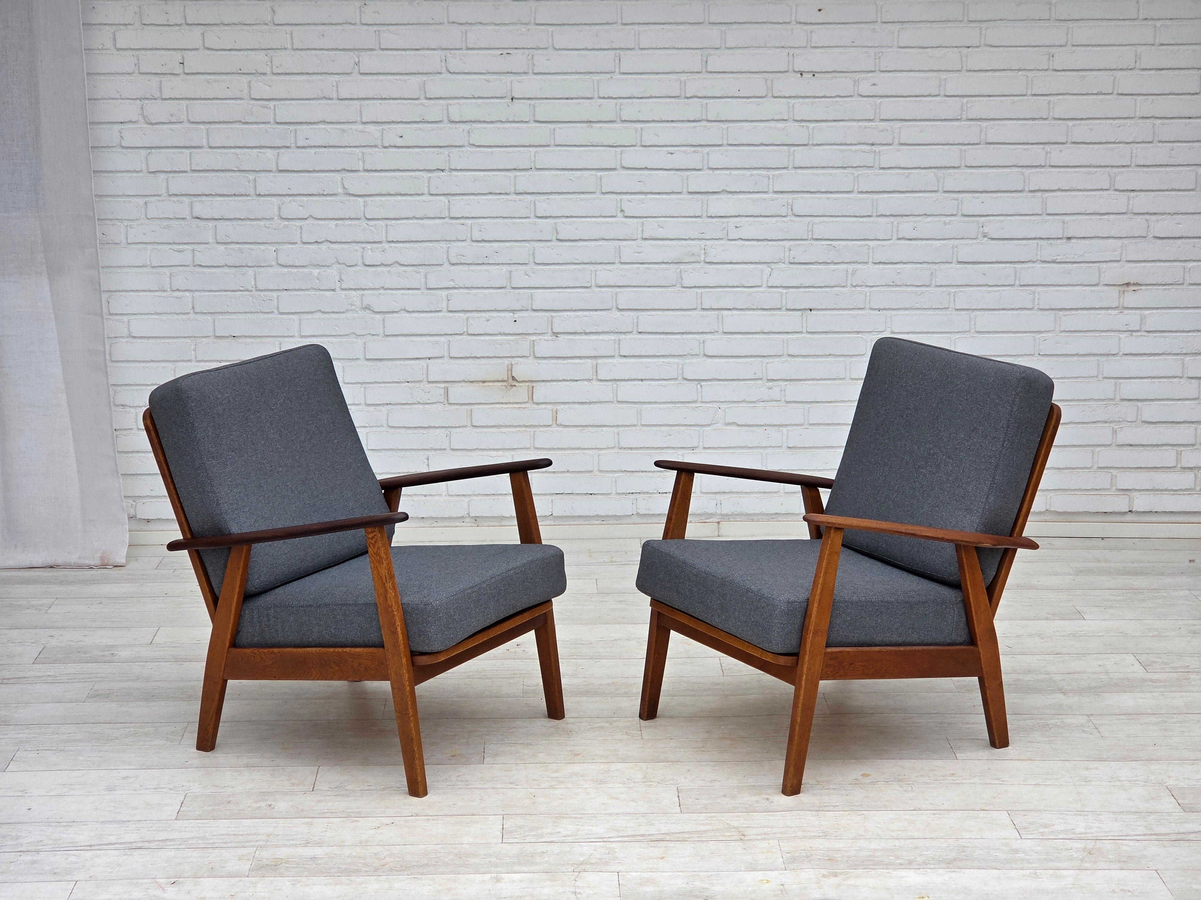 1970s, pair of Danish armchairs. New reupholstered, wood renewed. Quality blue furniture wool, teak wood armrests, oak wood legs. Springs in the seat cushions. Manufactured by Danish furniture maker in about 1970-75s. Reupholstered by craftsman.