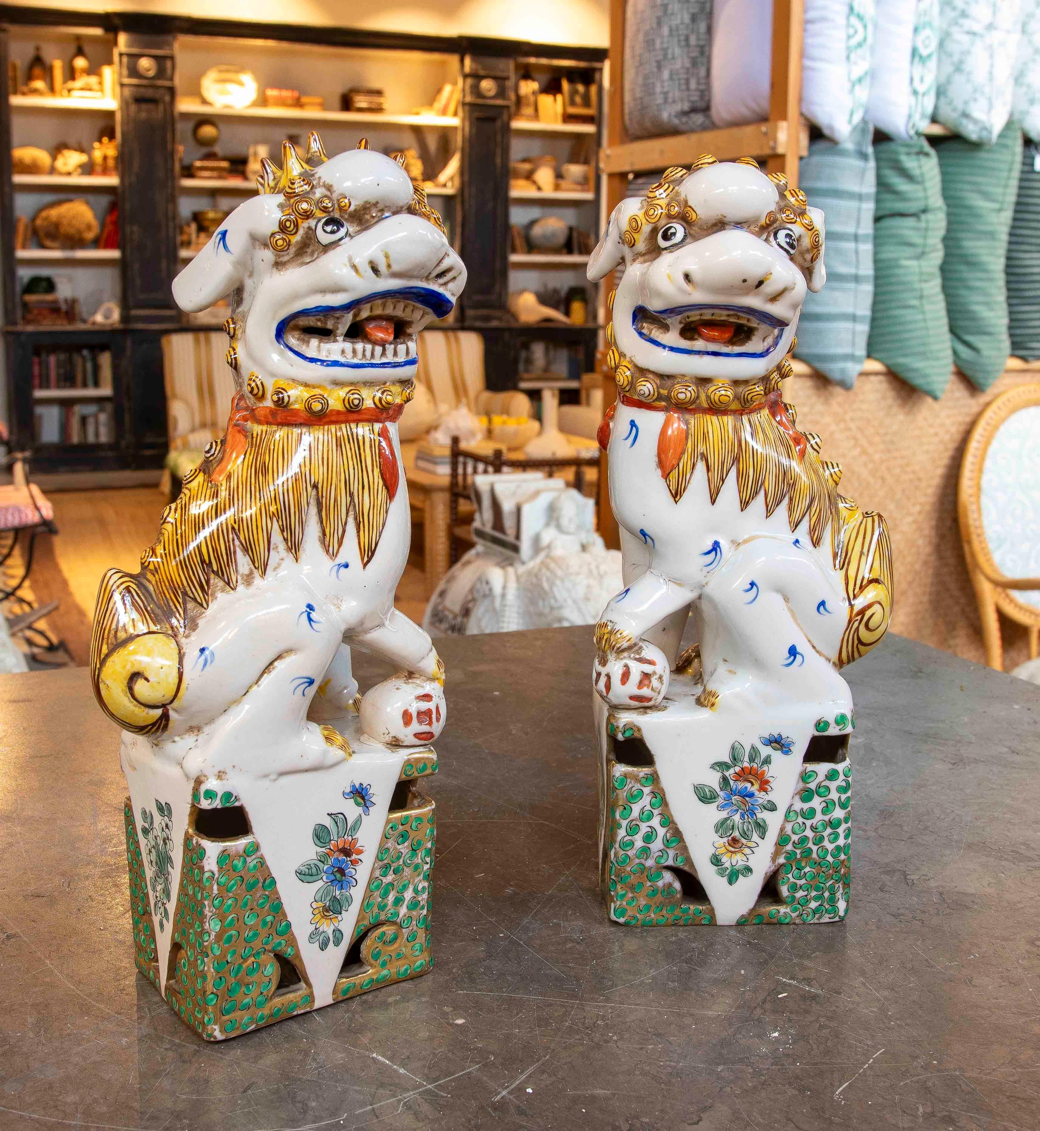 Magnificent pair of Foo Dogs, traditional figures of Chinese culture, crafted from glazed porcelain with vibrant colors and gold details. These sculptures represent Chinese guardian lions, symbols of protection, prosperity, and power.

Each figure