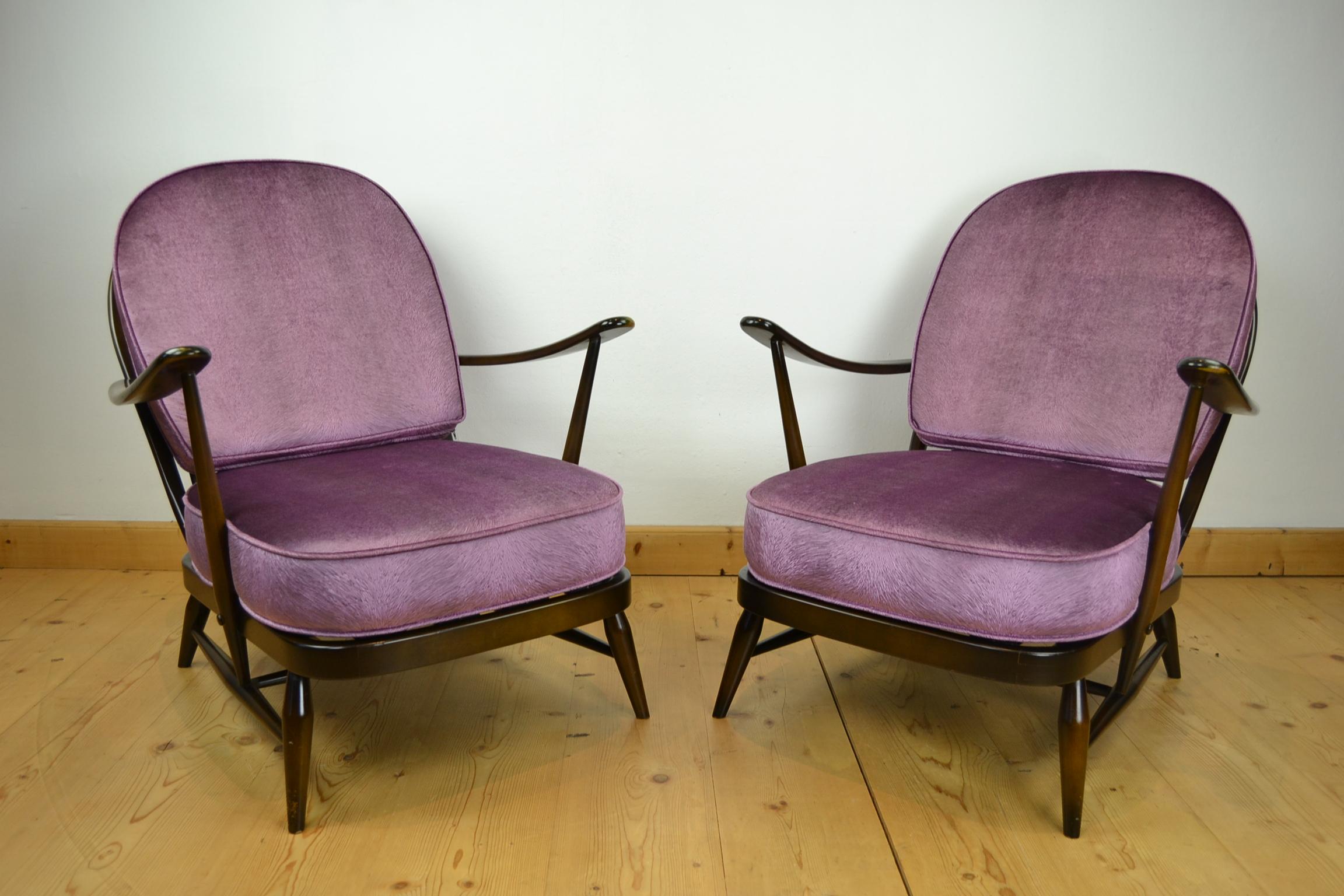 1970s set of 2 Ercol Windsor range armchairs.
These vintage armchairs with round stick backs are made of dark solid elm. 
Both still have their label under the seat, and are dated 1979. 

They got new cushions, made by a professional,
and