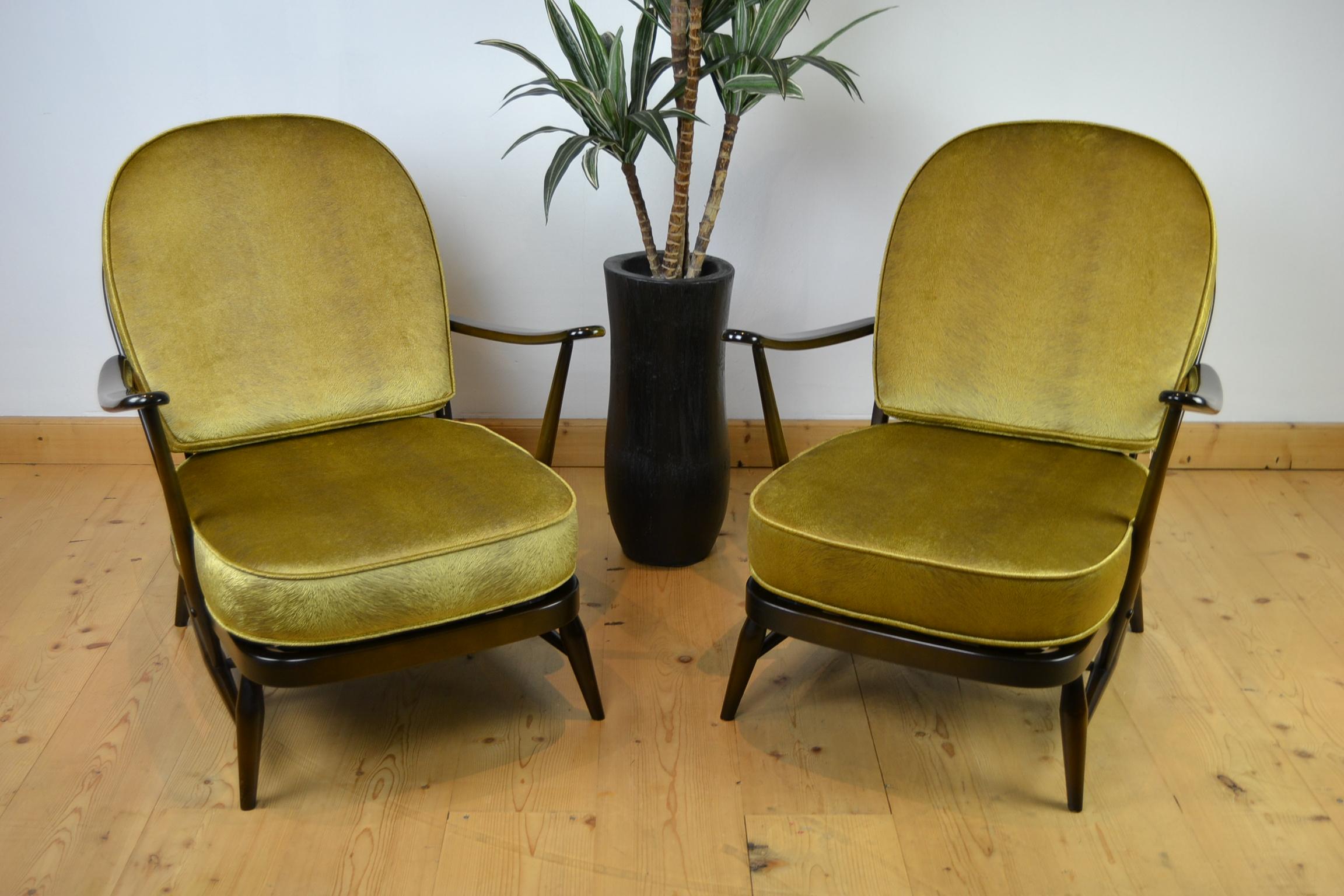 1970s set of Ercol Windsor Range armchairs .
These vintage armchairs with round stick backs are made of dark solid elm. 
Both still have their label under the seat, and are dated 1979. 

They got new cushions, made by a