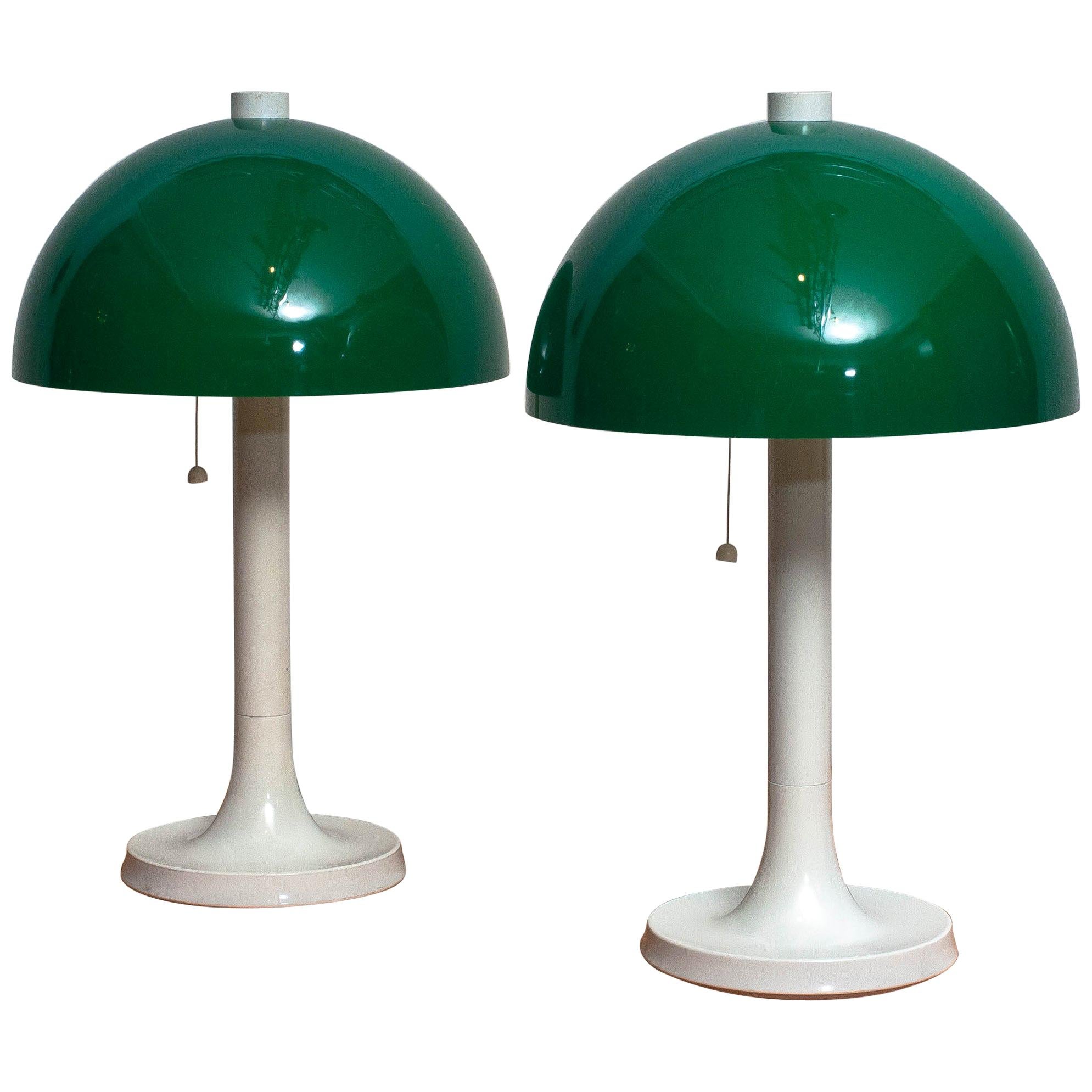 A nice set of two table or desk lamps made by Falkenbergs Belsyning, Sweden.
These lamps have white stands with green shades and each lamp has two fittings.
The lamps are in a nice condition wear consistent with age and use.