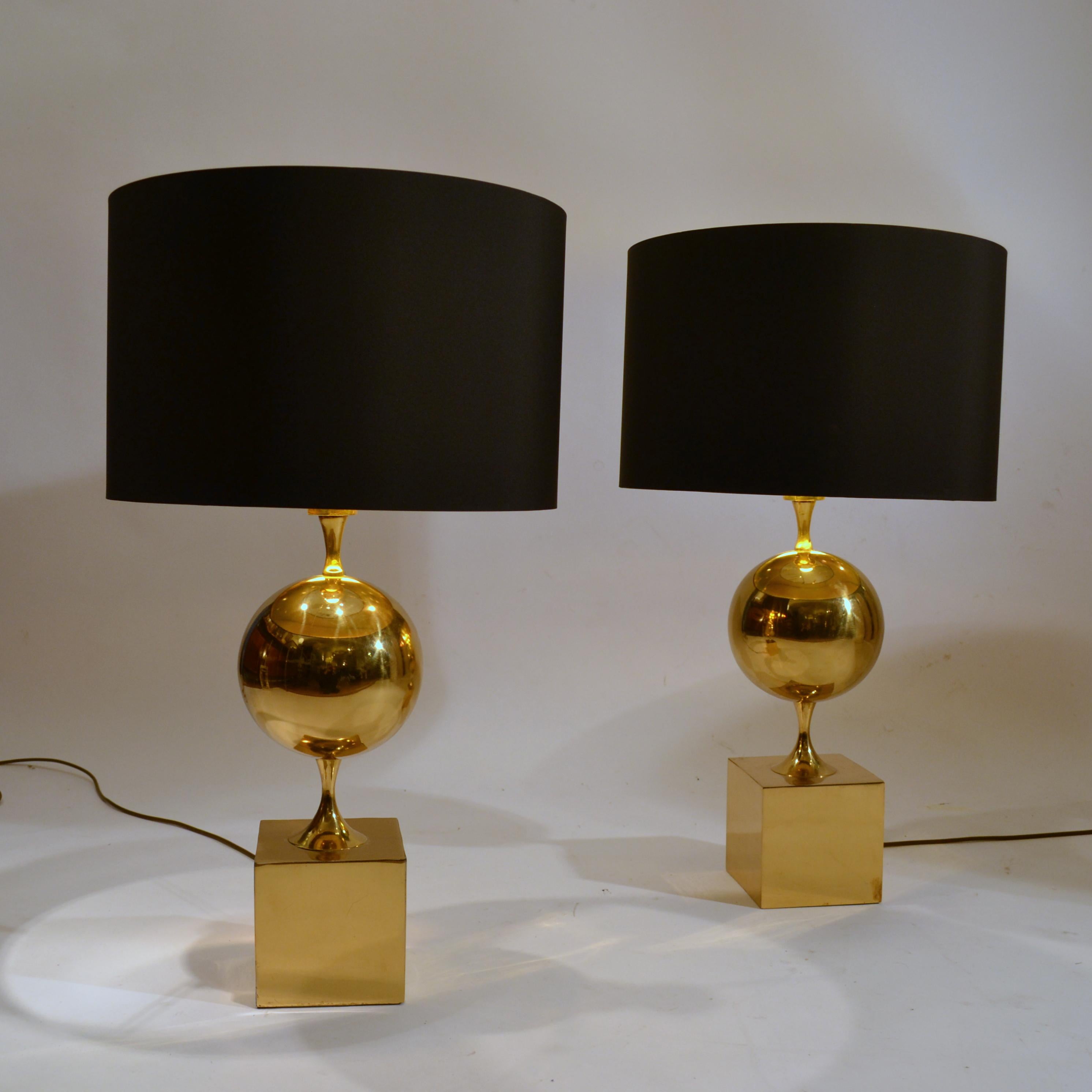 Elegant pair rare of 1970s polished brass table lamps by Maison Philippe Barbier, produced in a small workshop in the center of Paris. The simplest of geometric forms are made of a cube at the base followed by perfect sphere above. 
The black and