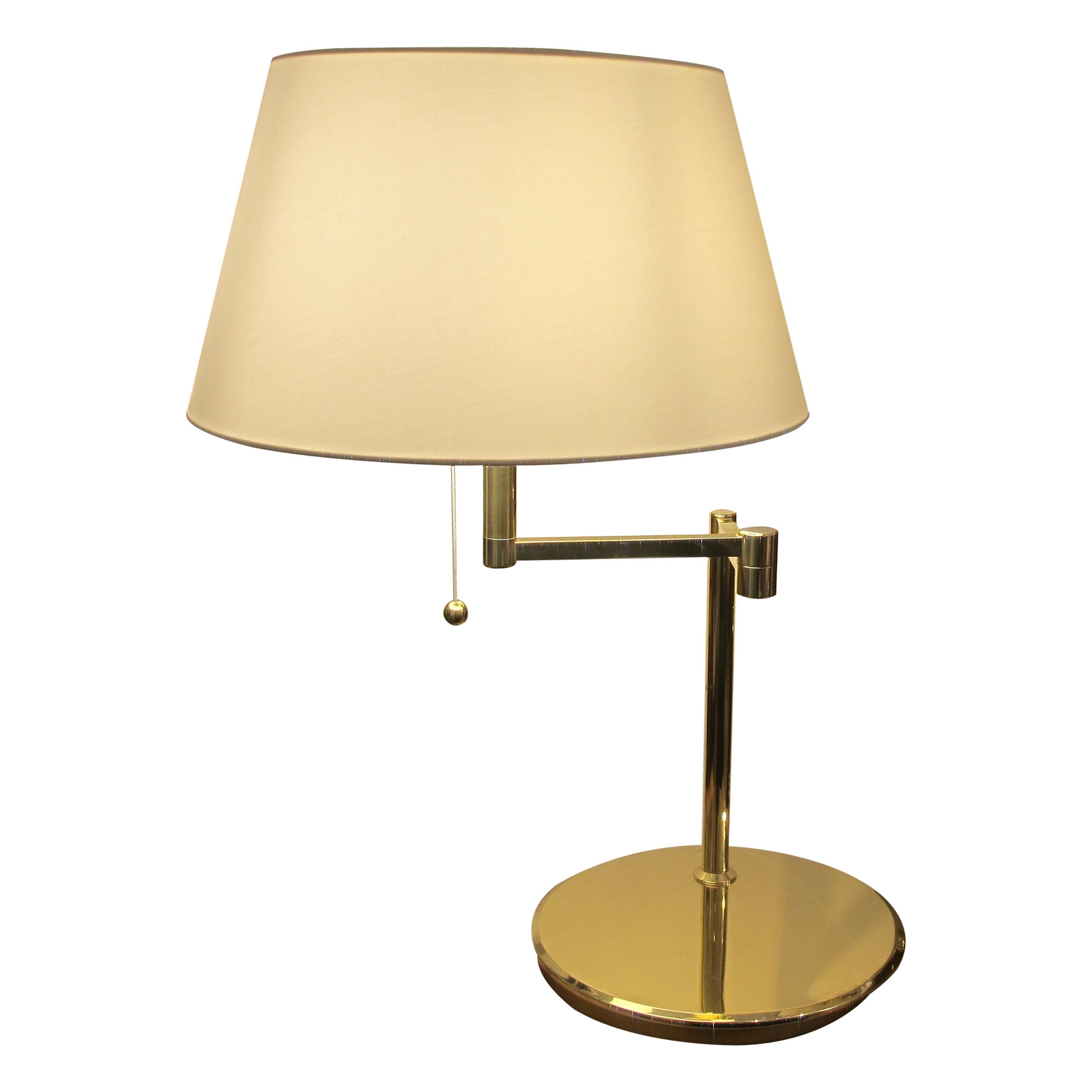 This elegant pair of large Swedish table lamps from the 1970s showcases a sleek and timeless design. Each lamp features a swivelling bracket arm, allowing the shade to move smoothly from left to right for optimal positioning and lighting. The soft