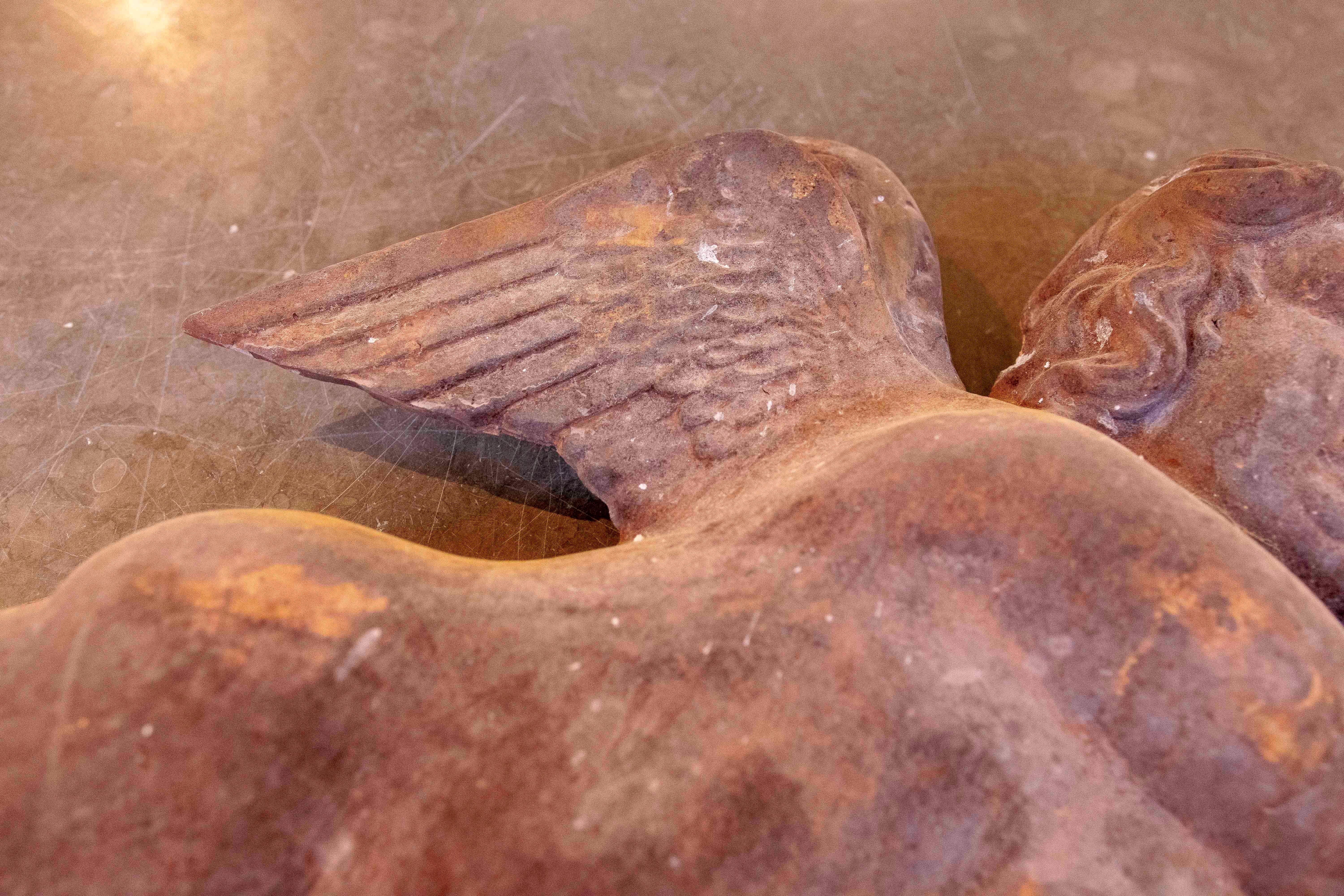 Paire d'angelots en fer ancien, d'une présence solide et d'une finition rustique qui rehausse leur caractère historique. Chaque figurine représente un ange ailé en mouvement, brandissant un arc et une flèche, symboles classiques de l'amour. La