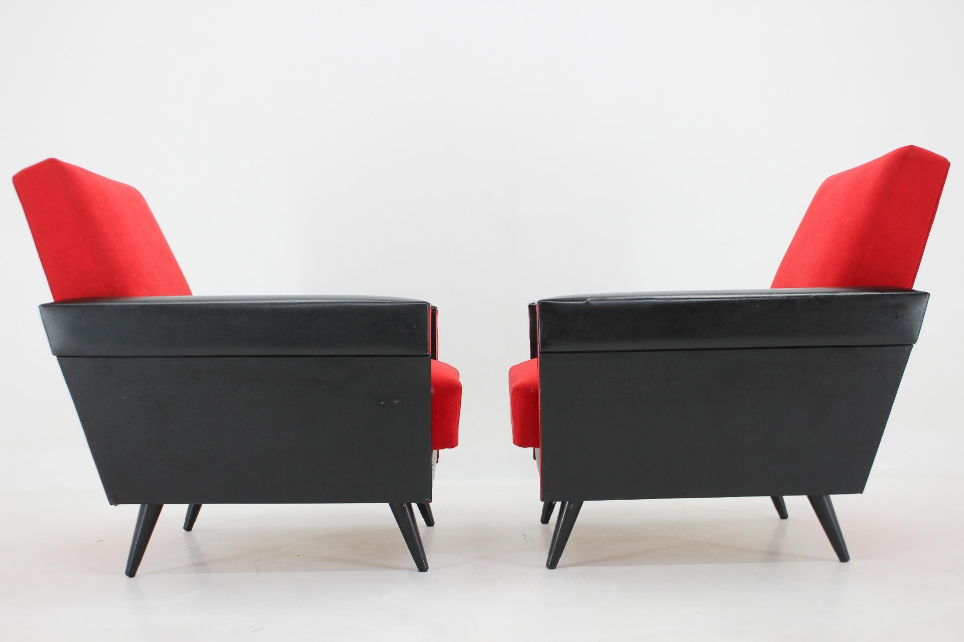 Paire de fauteuils rouges et noirs du milieu du siècle dernier provenant de l'ancienne Tchécoslovaquie. La sellerie est d'origine en très bon état avec quelques petits défauts sur la partie en similicuir (voir photo).