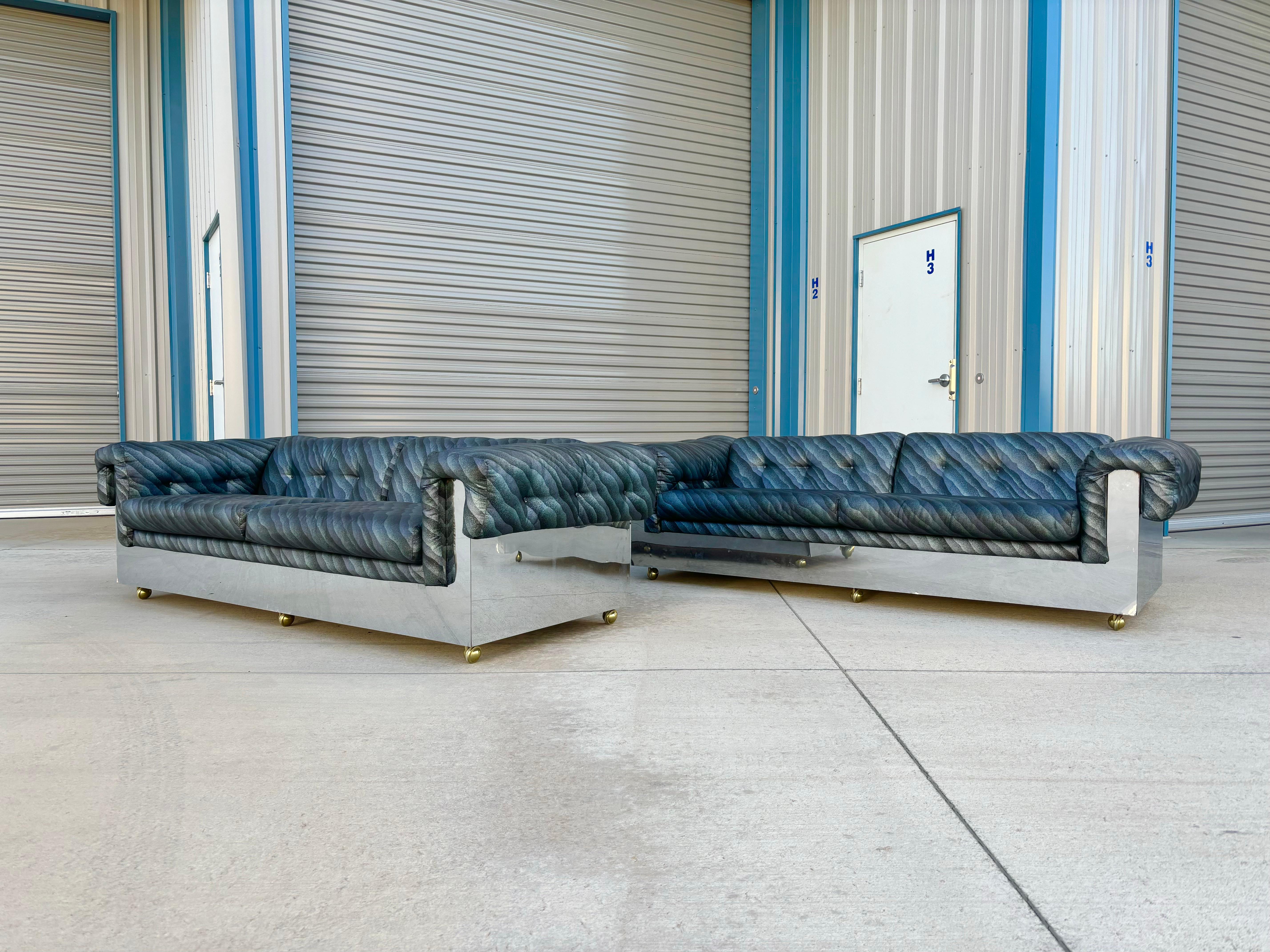 Pair of mid-century chrome sofas designed by Milo Baughman in the United States circa 1970s. These sofas are both stylish and functional, featuring a sleek chrome wrap-around design that adds a touch of modern elegance to any space. The sofa also
