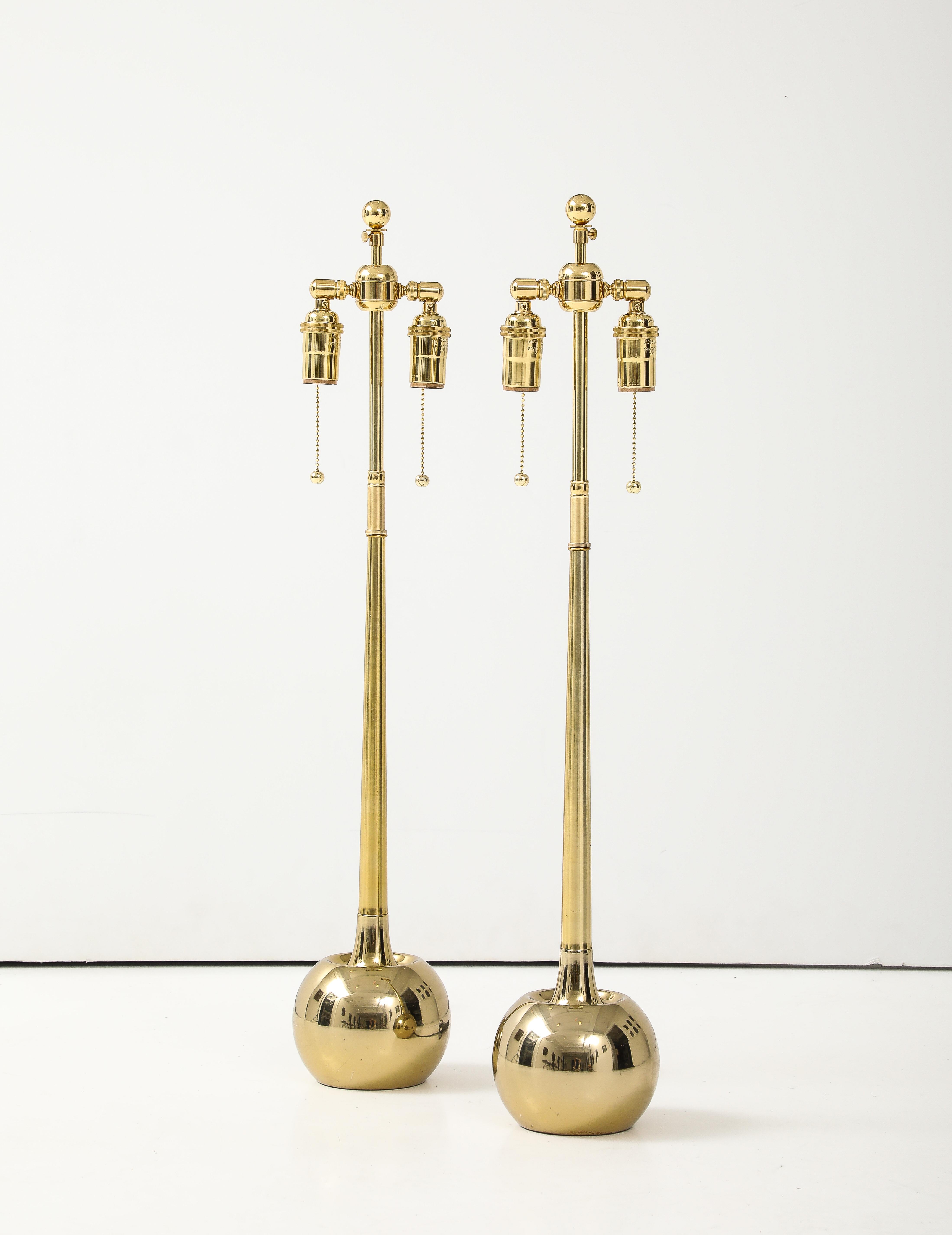 Paire de lampes boules épurées des années 1970 par Laurel lamp company.
La boule en laiton poli  Les lampes ont des cols effilés allongés qui se connectent aux doubles grappes en laiton poli réglable nouvellement câblées avec des cordons en rayonne