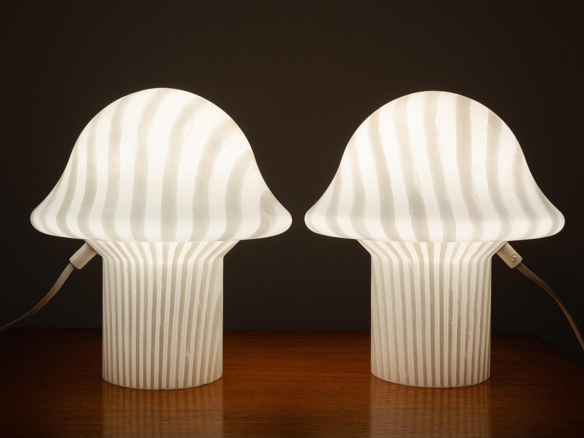 1970s pair of Peill and Putzler hand blown decorative mushroom table lamps. The lamps have a feature opaque internal stripe design running over them. made from one piece of glass. Perfect as bedside table lights perhaps in a kids room. In full