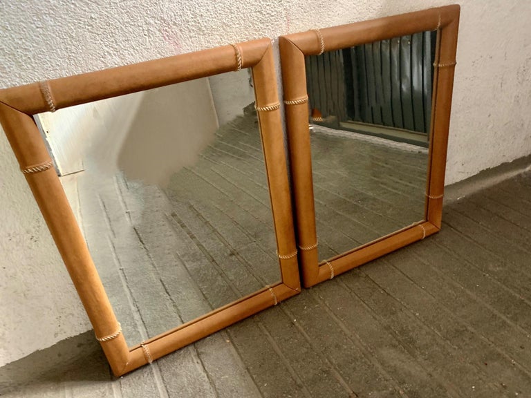Pair of mirrors from the 1970s, made in Spain with a light brown leather frame, with rope stitching all around.