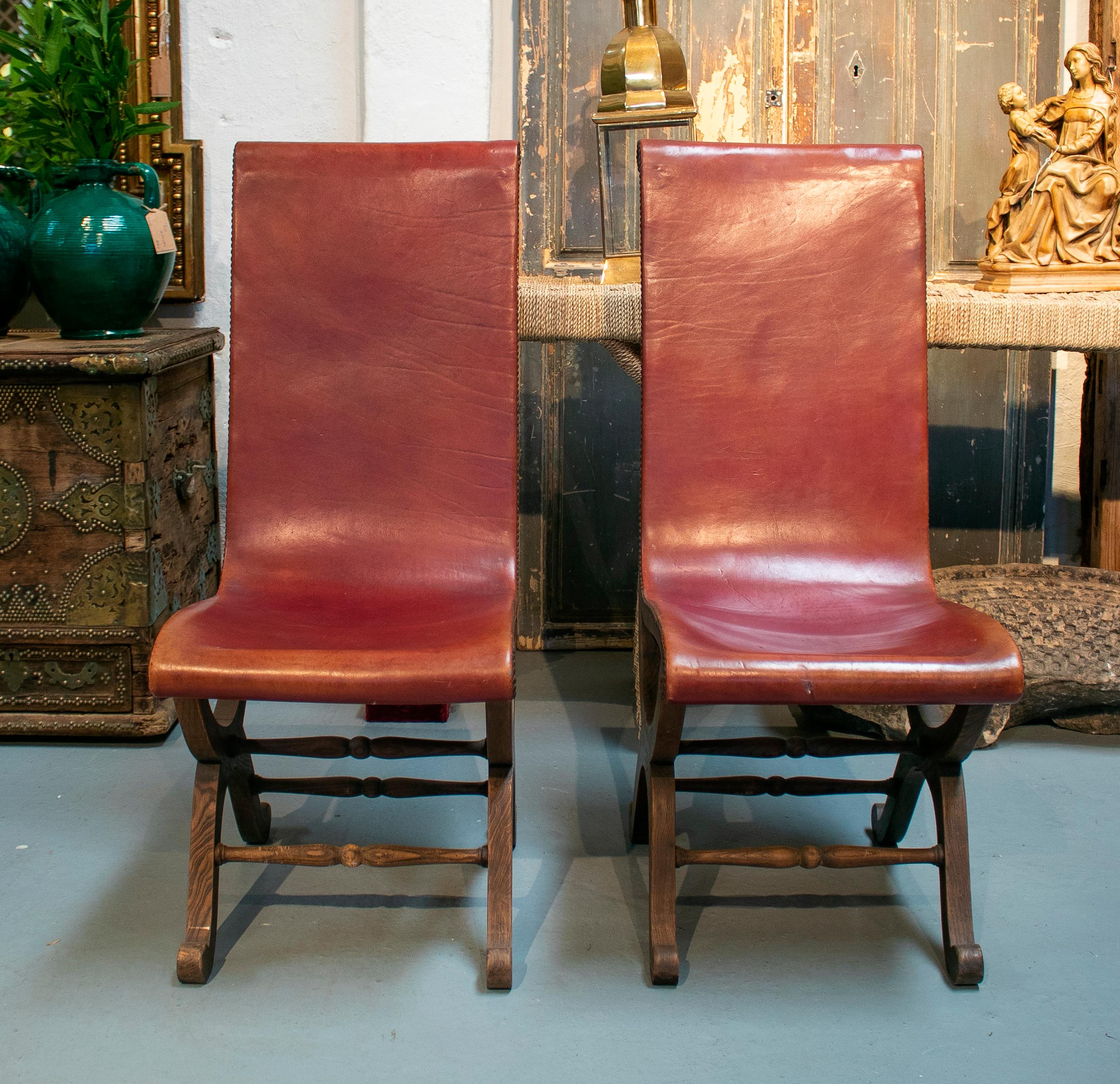 1970s pair of Spanish wood and red leather tall back chairs.