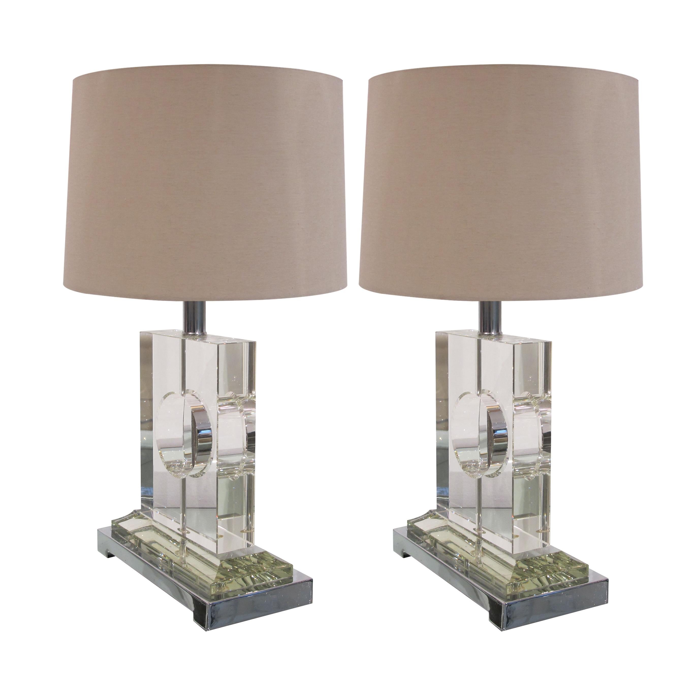 A stylish pair of Italian glass table lamps mounted on a rectangular chrome plated base. The lamps are of simple elegant design with a central chrome stem exposed through the centre of the circle. The lamps have been recently rewired. 

Size: H 37