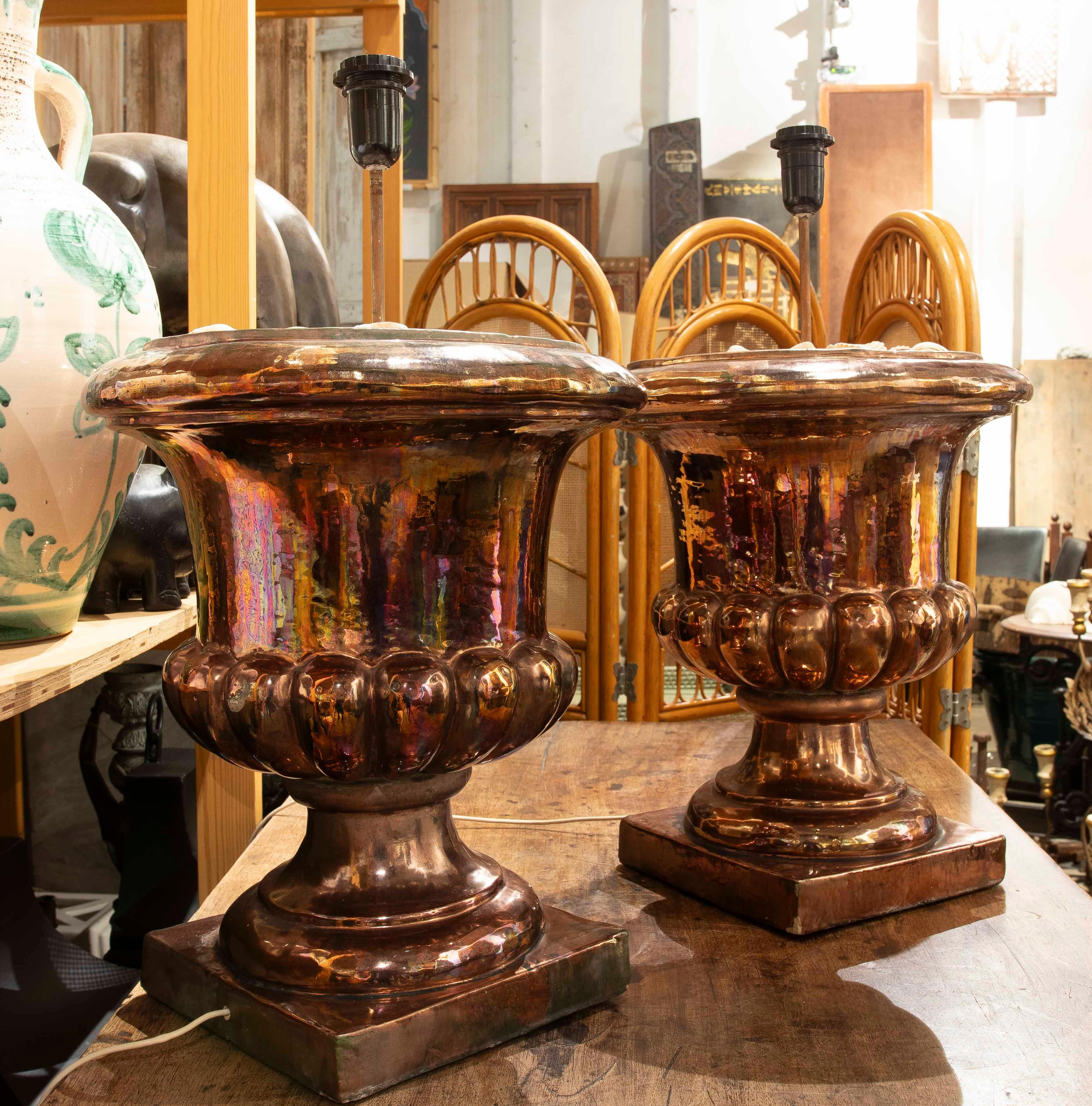 Crafted in ceramic with a glossy finish and multicolored reflections that evoke luxury and sophistication, these table lamps feature a classic goblet shape. Each piece is adorned with fluted details at the base, enhancing their decorative appeal.
