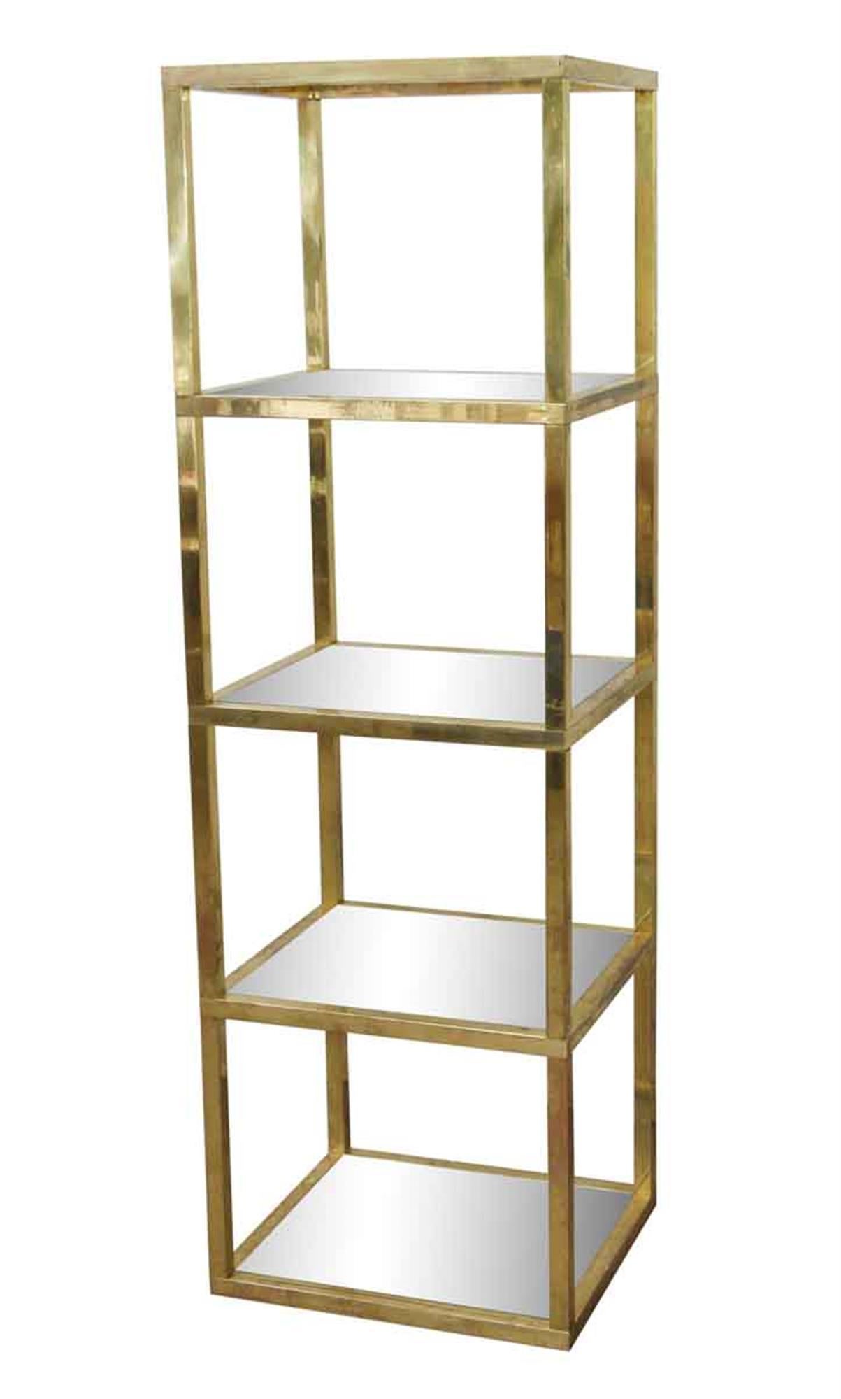 1970s tall polished brass shelf units with five glass shelves done in a Mid-Century Modern style. Priced as a pair. This can be seen at our 5 East 16th St location on Union Square in Manhattan.